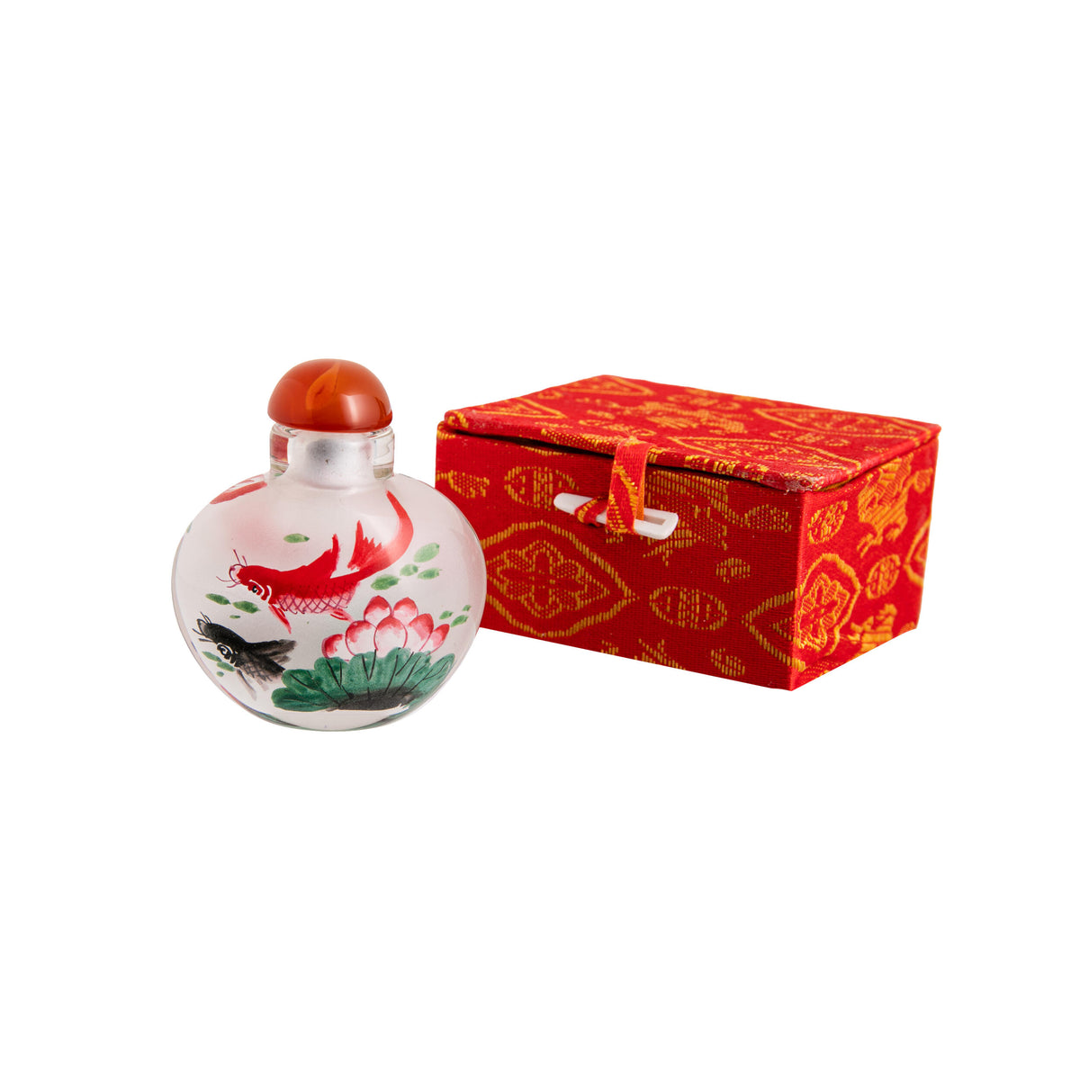 Decorative traditional Asian snuff bottle with floral and koi carp design next to a red box on a white background