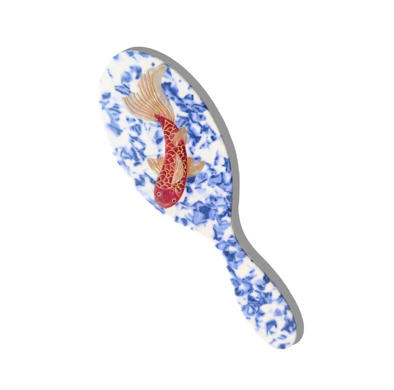 This gorgeously striking hairbrush features a design with a vibrant Koi carp swimming in beautiful blue waters. It is finished with hand-painted details and is crafted in small batches.