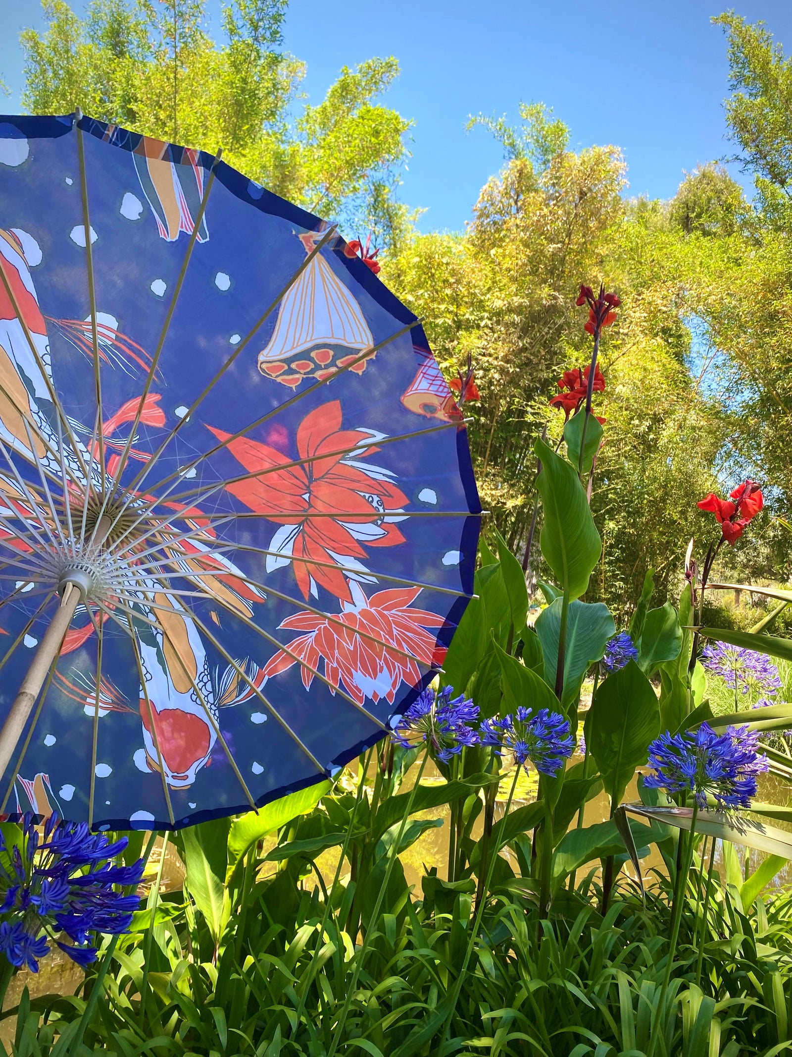 This pretty striking Koi fish print on a midnight blue background is perfect for keeping the sun's rays at bay, and also offers a beautiful way to dress up any special event outfit. Built from silk nylon, this parasol can also be hung upside-down as a striking decoration piece. Length when closed: 25.5".
