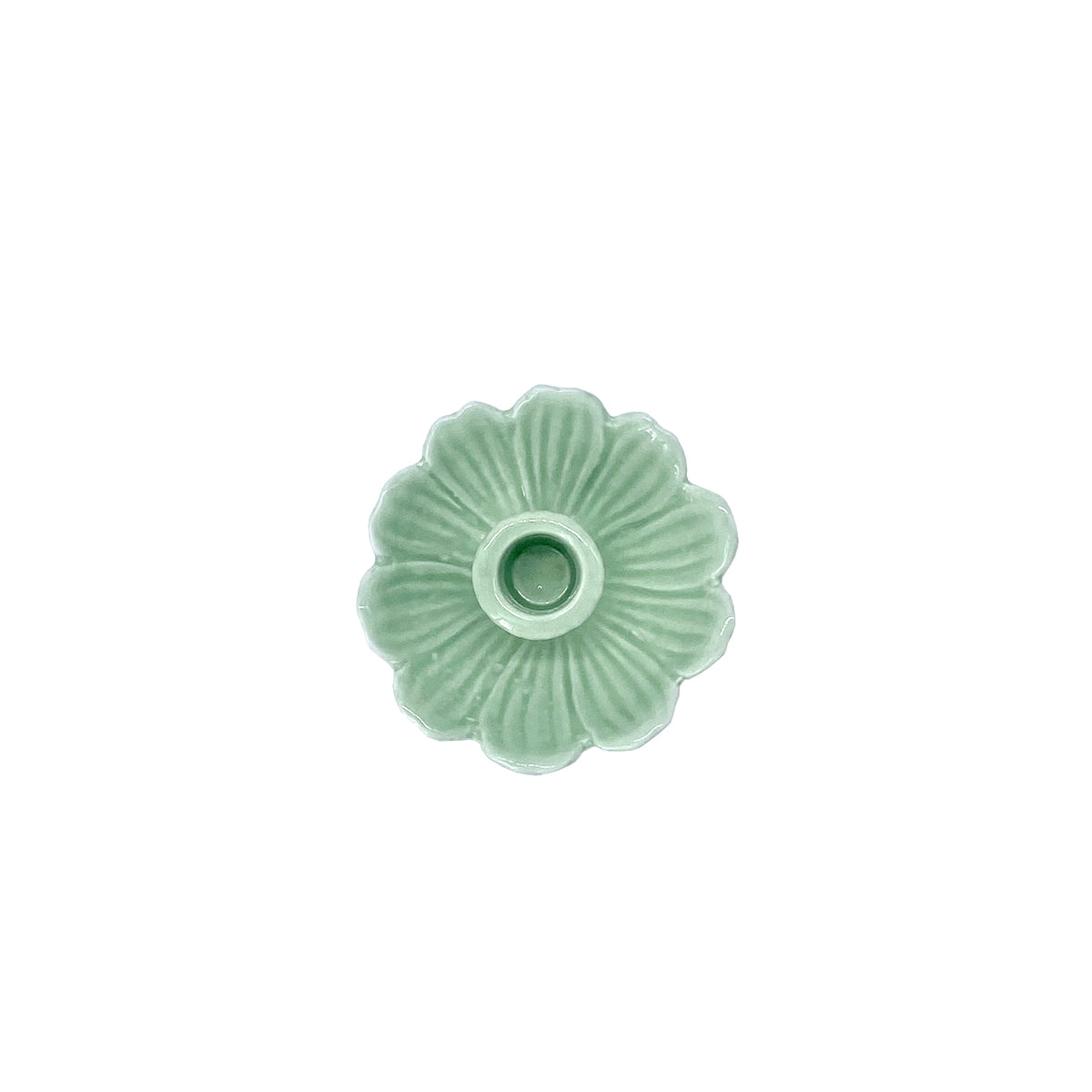 Green ceramic flower-shaped candle holder on a white background