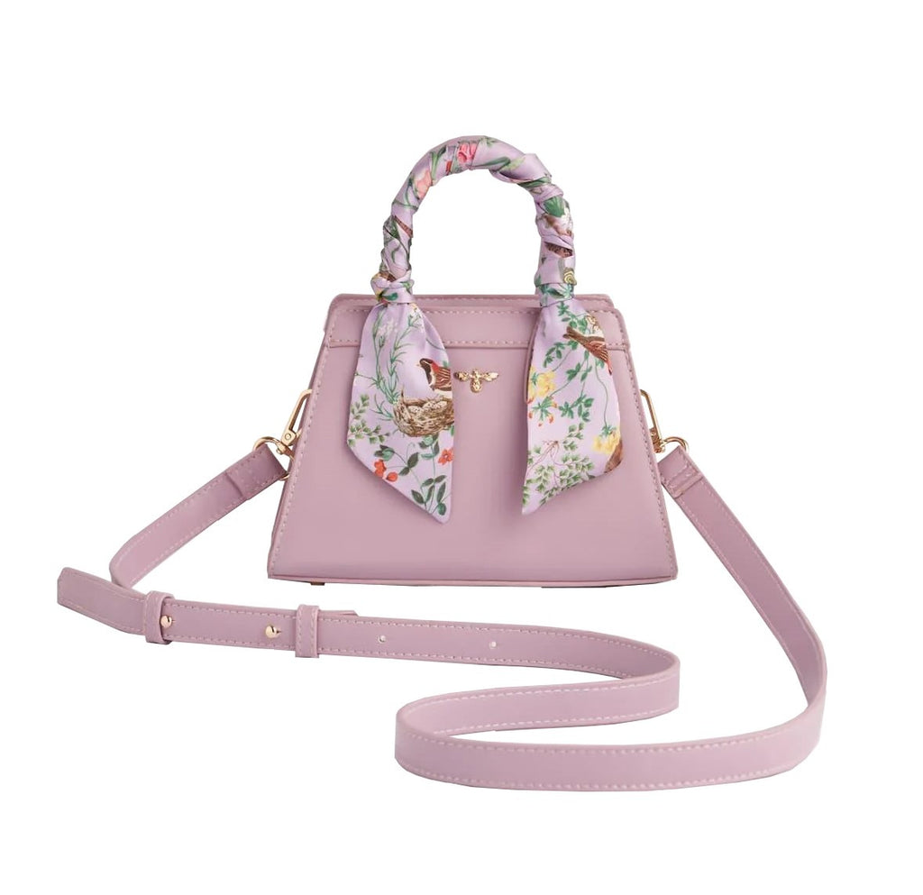 This refined mini structured tote in the prettiest orchid hue is a chic addition to any work or occasion wear look. Its timeless, elegant style adds a feminine aesthetic to any outfit. Comes with a silky scarf wrapped around the handle.  7" x 8.5" x 3" Materials: Vegan 'leather'. Includes a detachable shoulder strap.