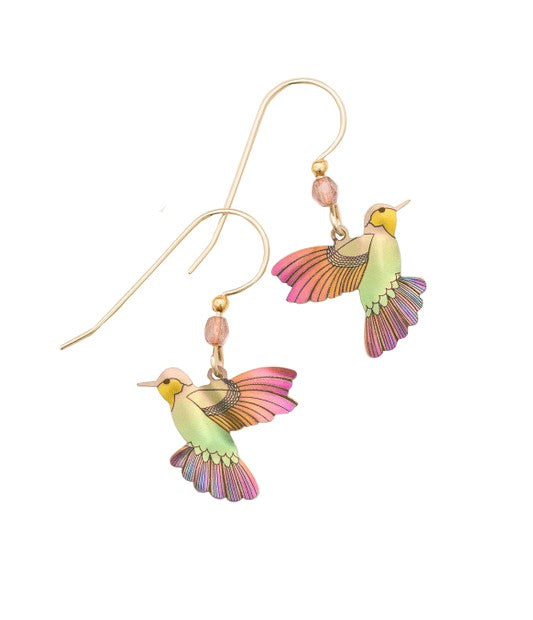 Sweet, vibrant, joyful. These earrings embrace the essence of this magical creature. Dainty hummingbirds artfully detailed and hand-colored with exhilarating hues flit about from delicate ear wires. The perfect peek-a-boo style to dress up any look. • Niobium • Gold filled ear wires • 1 1/4" l. x 3/4" w.