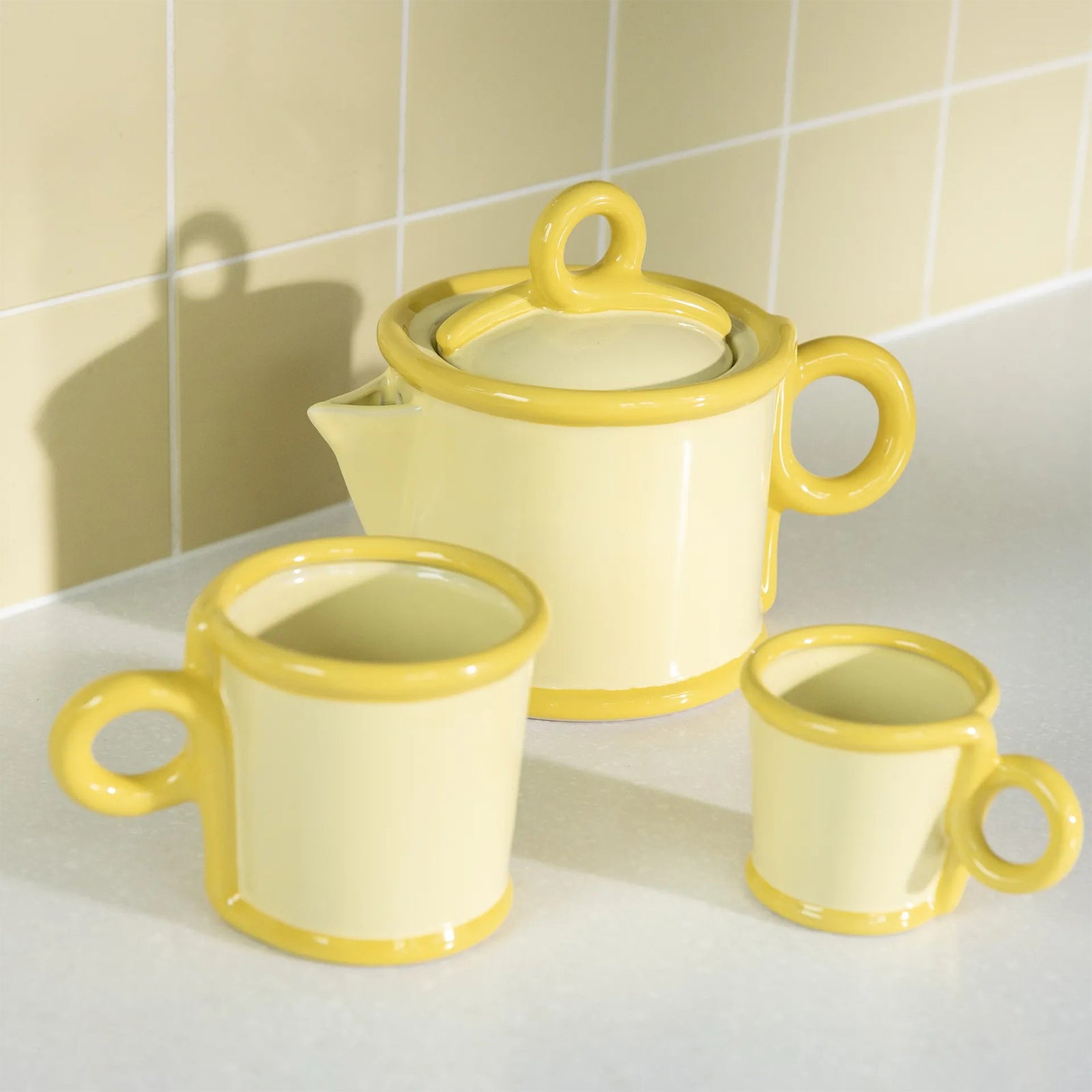 Two yellow ceramic espresso mugs on a white background