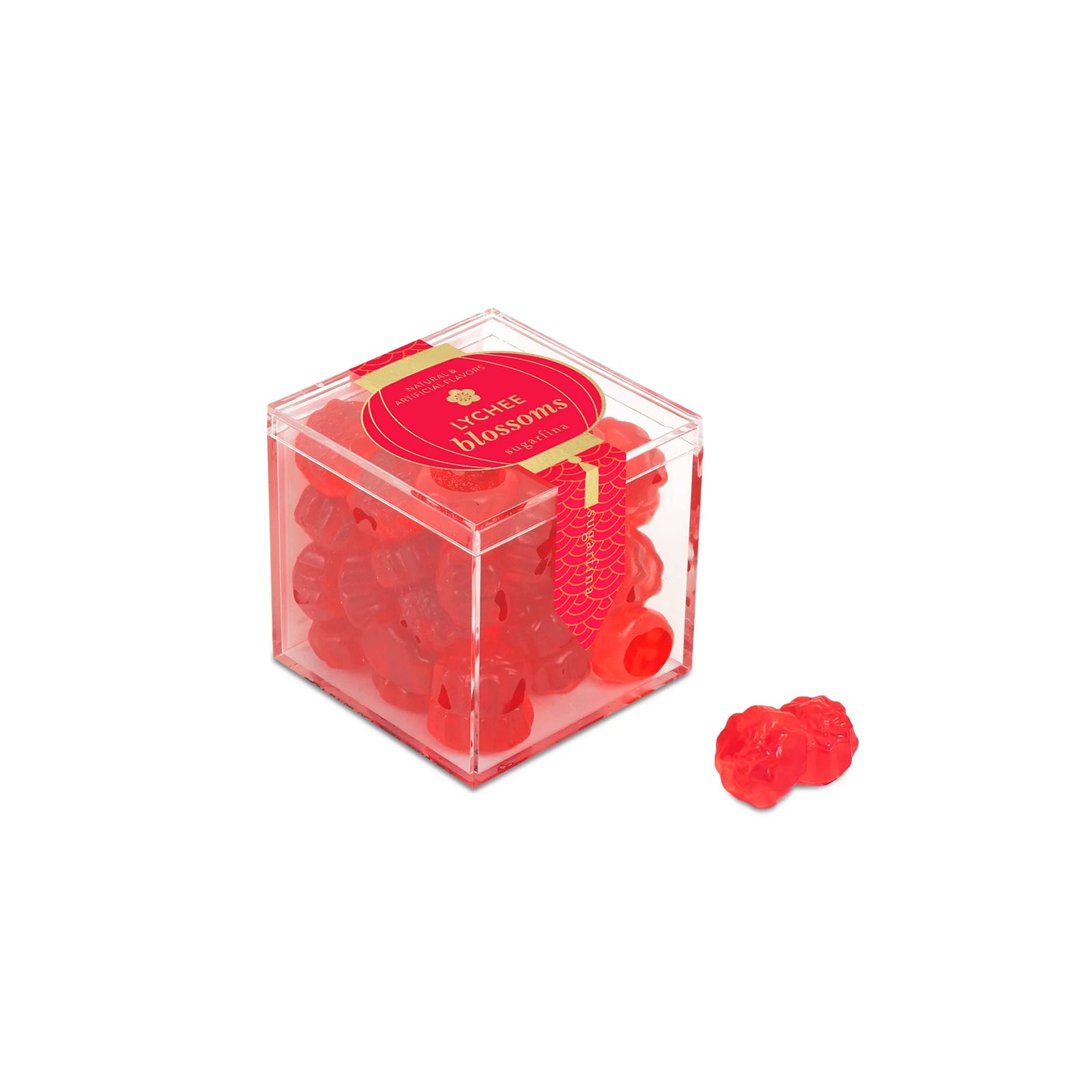 Red gummy candied shaped like flowers in a clear cube container on a white background