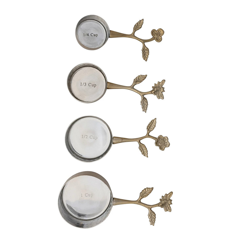 Elevate your cooking and baking experience with these delightfully elegant stainless steel and cast aluminum measuring cups. This set of four cups includes 1/4 cup, 1/3 cup, 1/2 cup and 1 cup. Each cup features a flower or a bee on the handle, and all have a hammered brass effect finish. Set of four measuring cups Material: Stainless steel, cast aluminum. Hand wash.