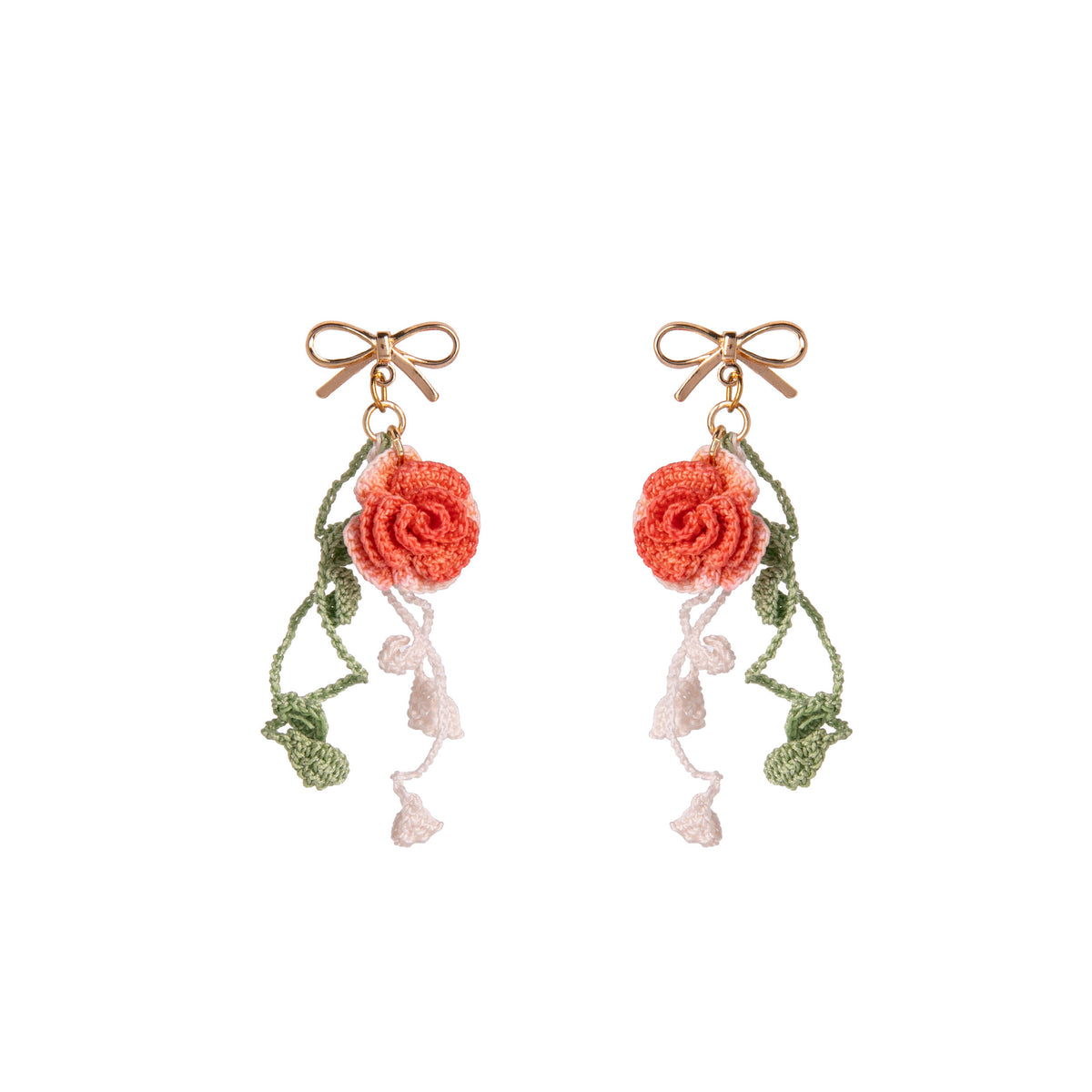 Pair of floral earrings with coral roses and green leaves on a white background