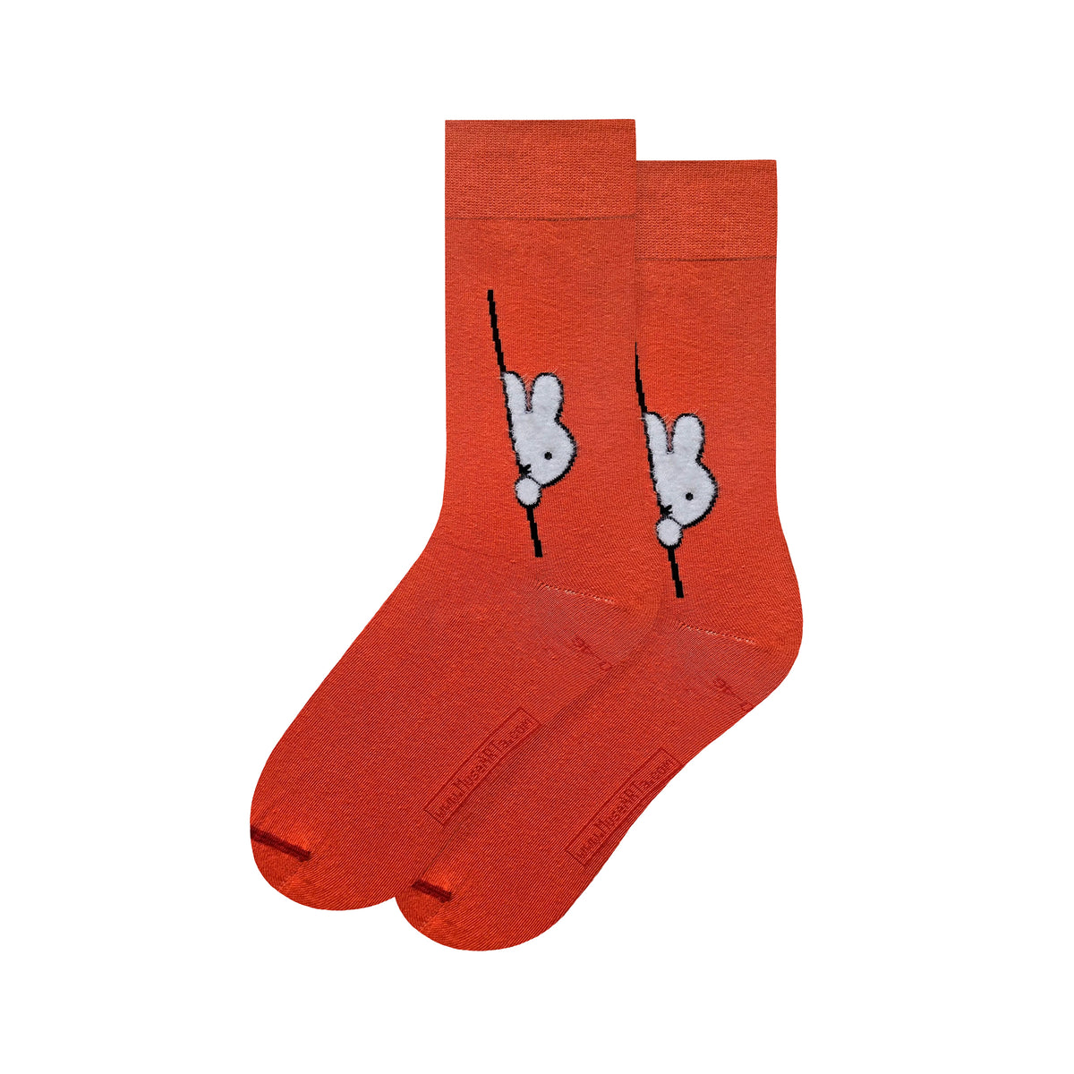 A pair of bright orange crew socks featuring a white rabbit, Miffy by Dick Bruna, peeking out from behind a black pole graphic on the side, displayed against a solid white background.