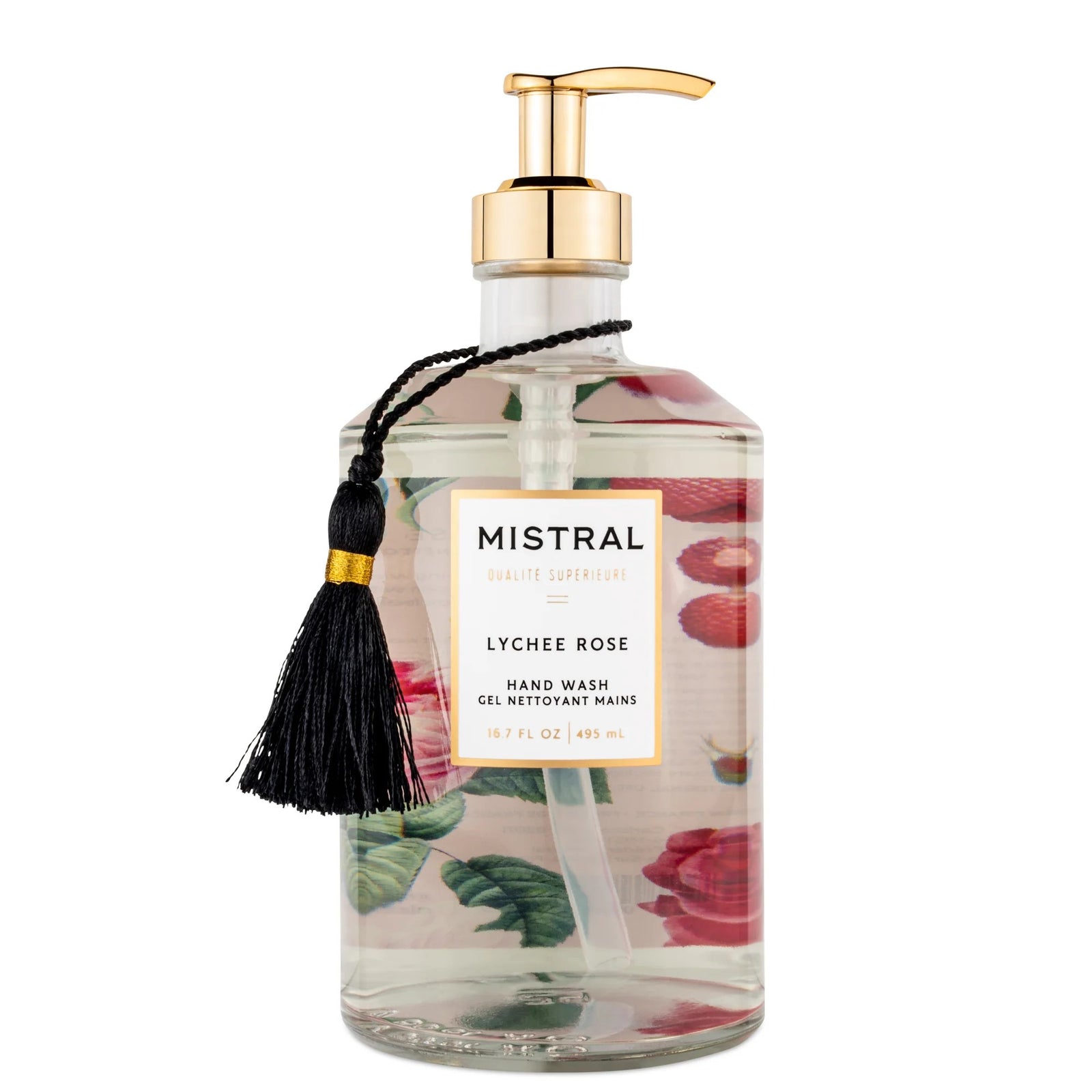 A clear glass bottle with a gold pump, labeled 'MISTRAL LYCHEE ROSE', featuring a vintage rose print design and a black tassel.