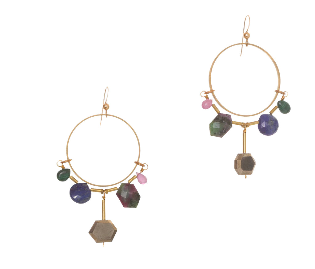 These striking statement earrings feature an array of rich, luxurious hand-cut gemstones. The on-trend skinny hoop shape, accented with beautiful gems will add an elegant pop to any outfit.  Materials: Lapis, Malachite, Ruby Zoisite, Ruby & Pyrite. Recycled brass hoops. 14k gold-fill earwires Dimensions: 2.5" x 1.5".