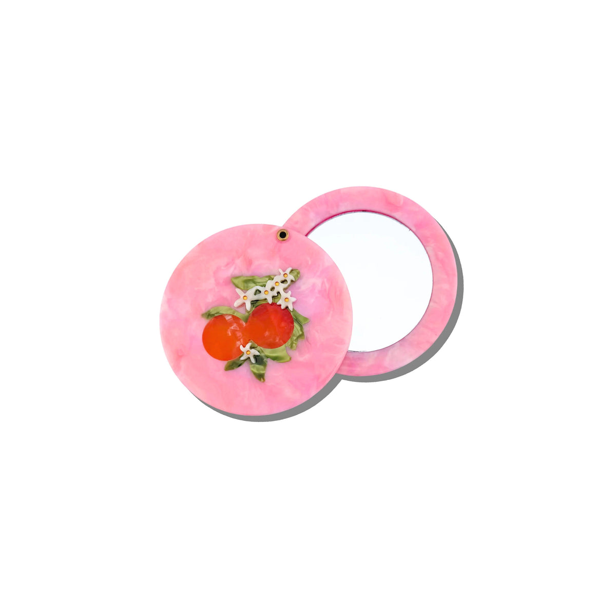 A pink circular accessory with a glossy finish, featuring a small decorative floral and fruit motif in red, orange, and green on the front, shown against a plain white background.