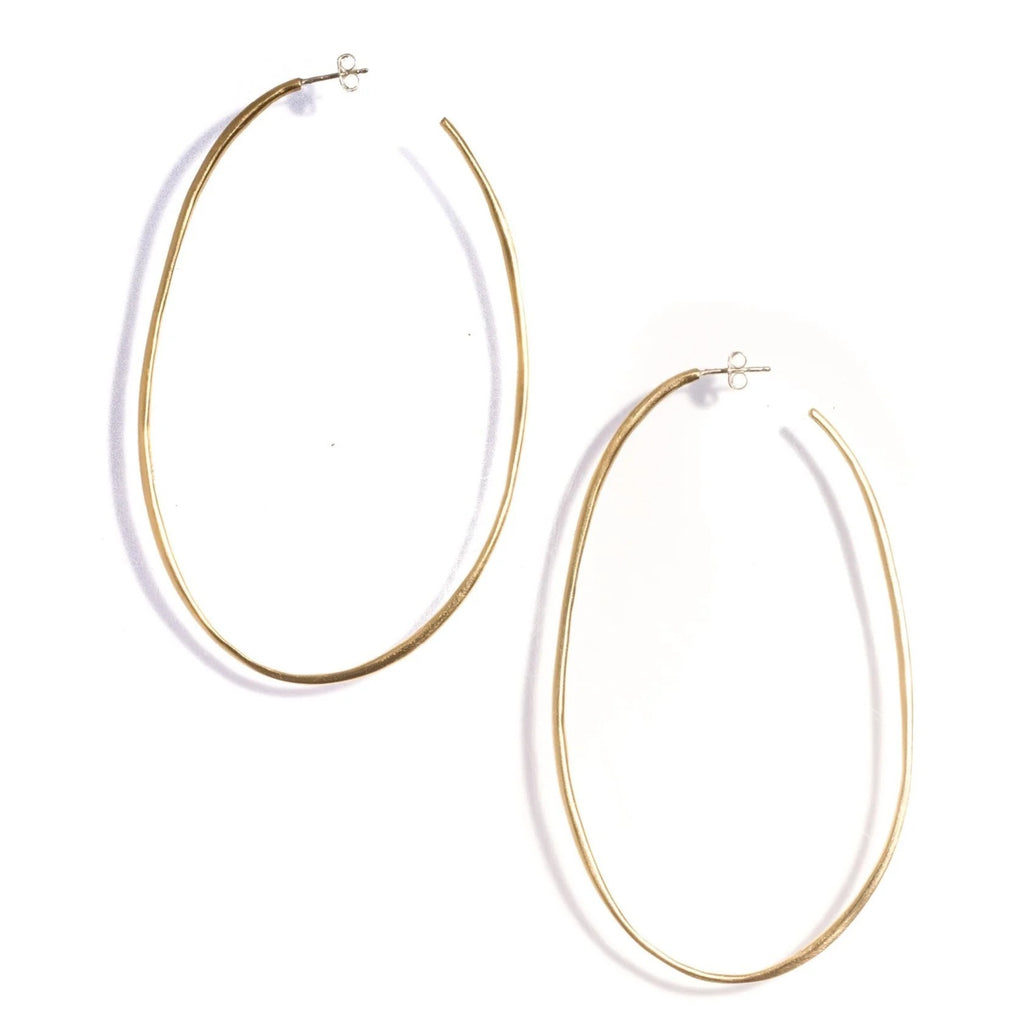 These oversized but lightweight brass hoops offer both understated chic, and a statement in one! Wear with jeans and a plain white tee for a classic yet modern casual look. Material: Hand-cast brass. Sterling silver posts Dimensions: 3.5" long x 1.15" wide Handmade in the USA.