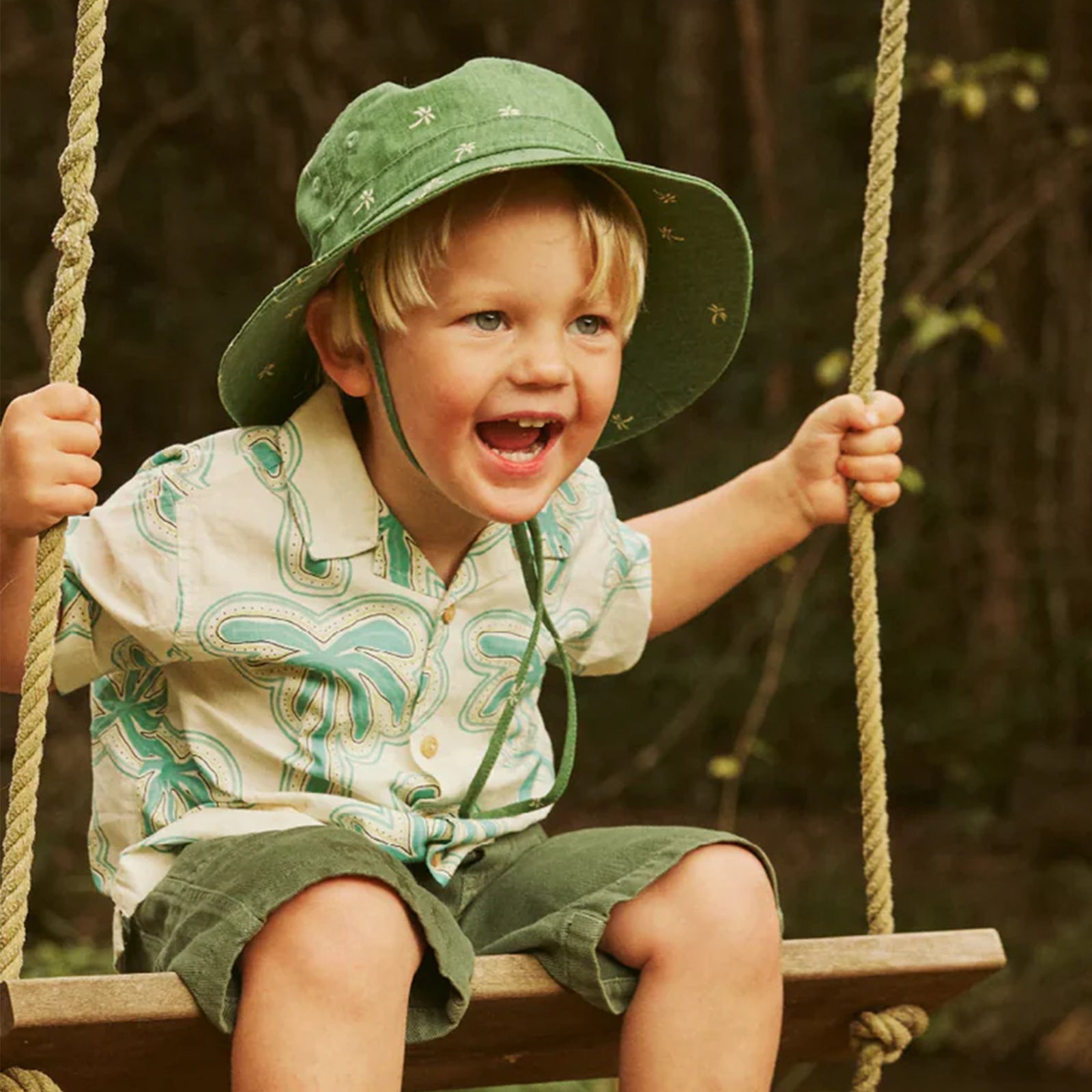 Green baby bucket hat with floral pattern on a white background