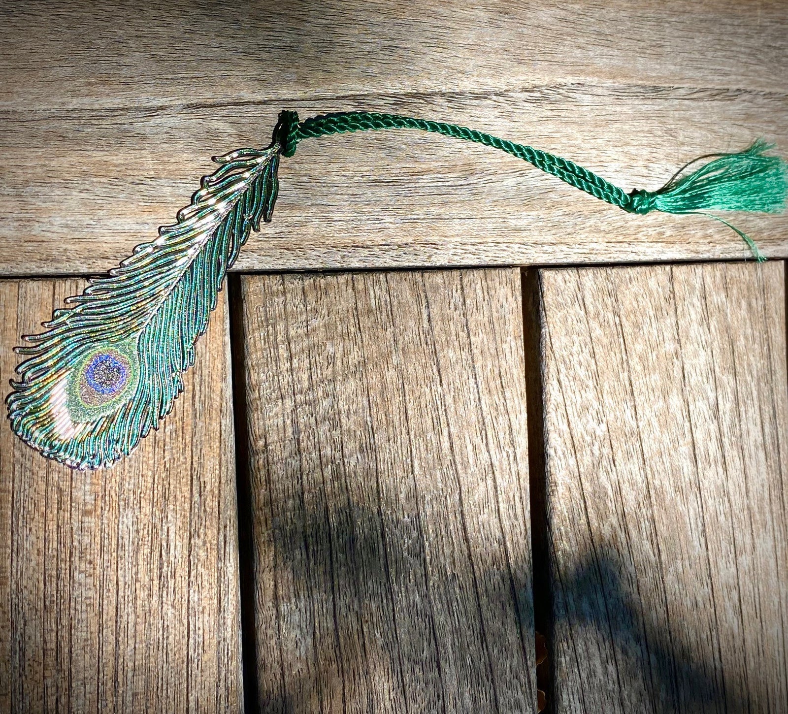 This bookmark is inspired by Auguste Delaherche’s peacock vase, which was shown at the Exposition Universelle in Paris in 1889. Delaherche used peacock feathers for their iridescence and exoticism. A popular Art Nouveau motif, they appeared on Tiffany glass and other decorative arts.  Solid brass. 1.25" W x 3.75" L.