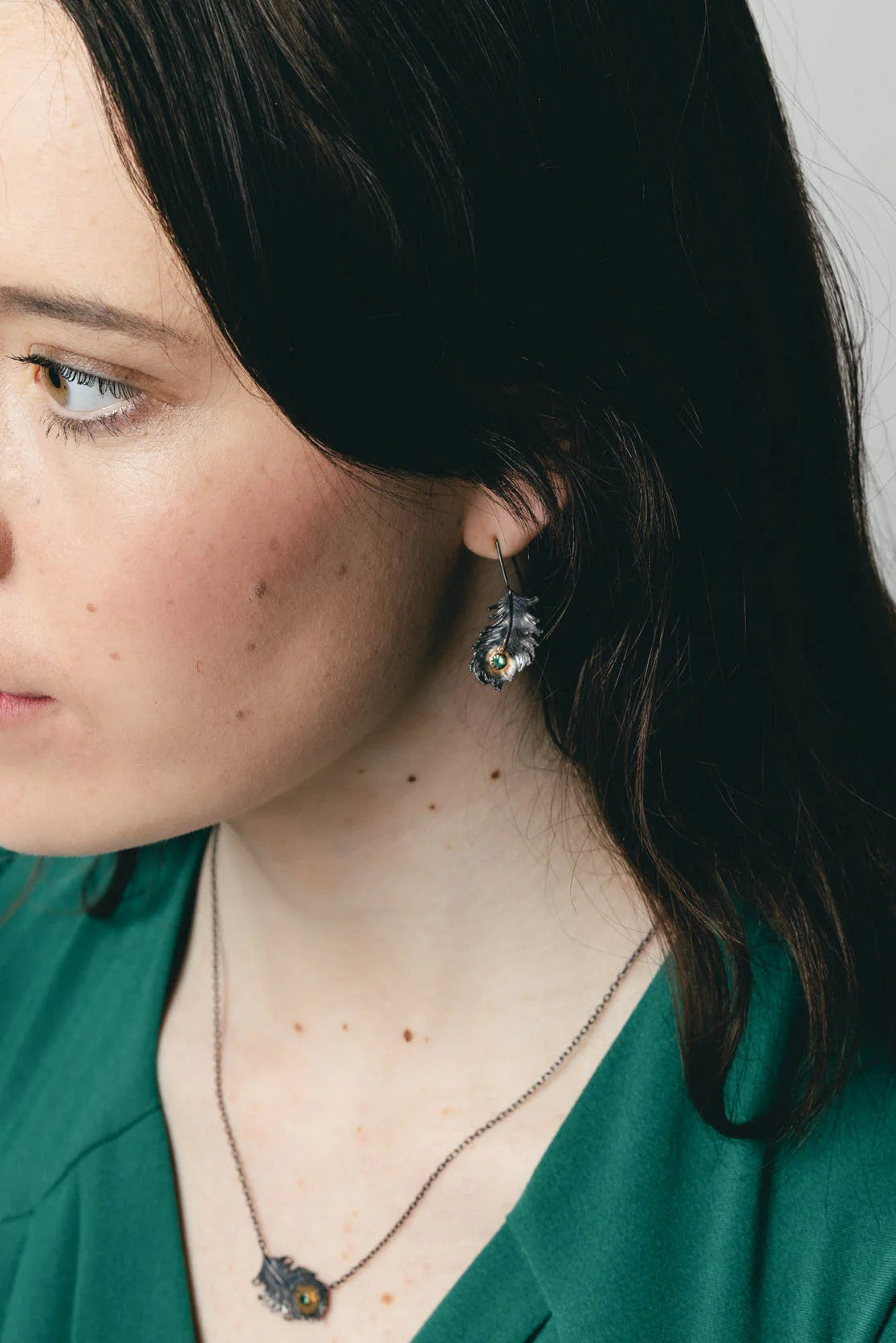 Necklace with a feather-shaped pendant on a white background