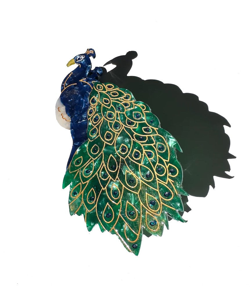 This gloriously colored and beautifully detailed peacock hair clip captures this regal bird in all its fine feathered fabulousness!  This unique hair clip is hand finished and carefully crafted from cellulose acetate, an eco-friendly, biodegradable material made from recycled wood pulp. Dimensions: 5" x 2.5".