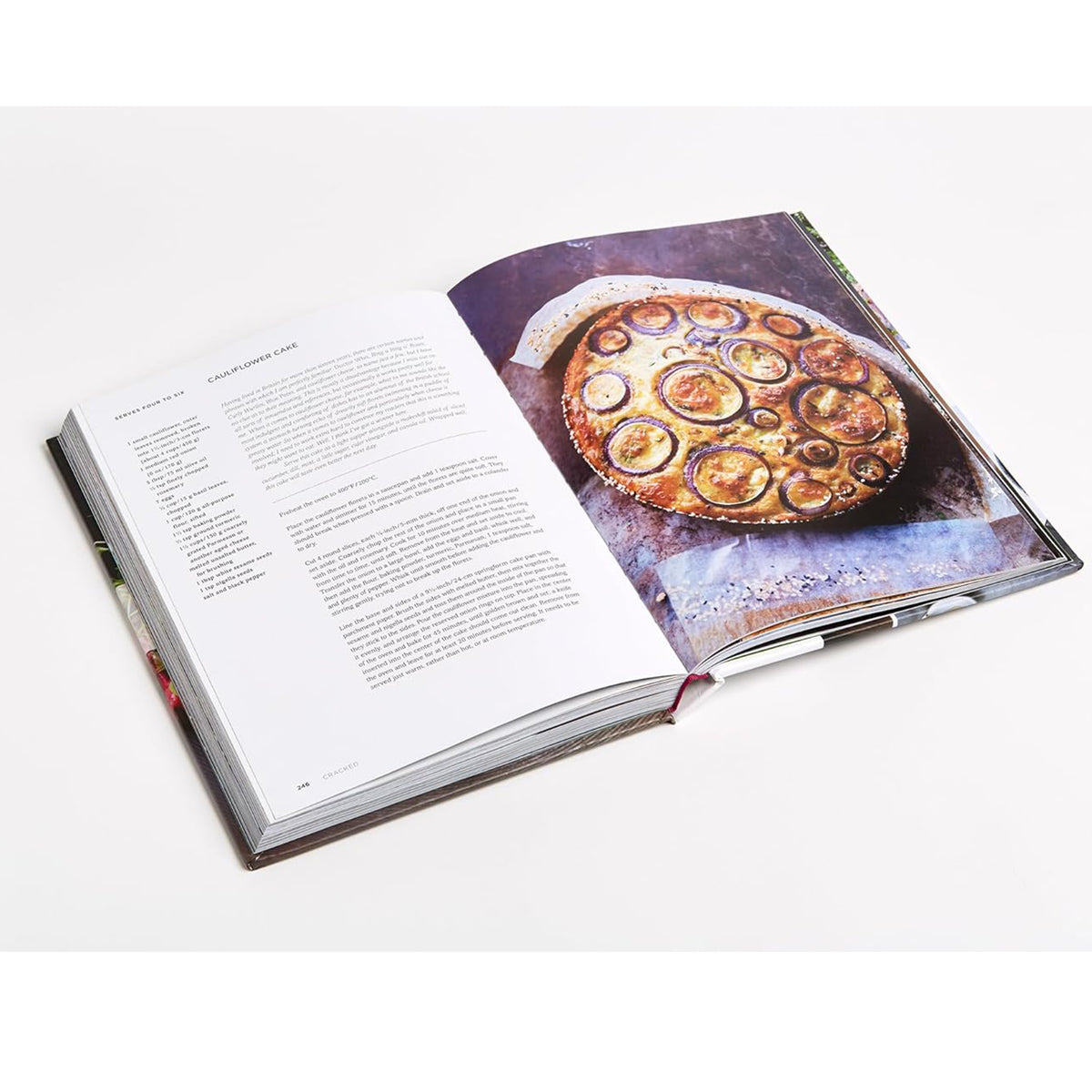 Open book with a photograph of a pizza on one page and text on the other, on a white background