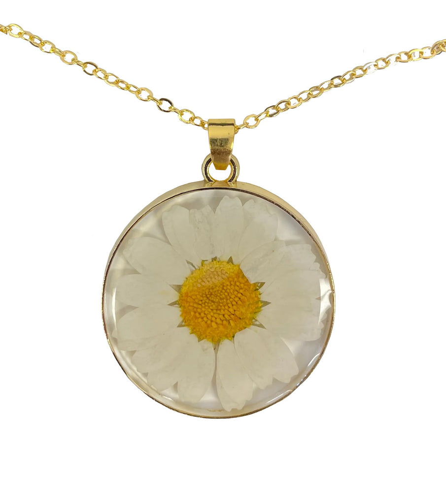 Embrace your inner flower-child with this daisy pendant necklace. This unique necklace features a pendant of a real pressed daisy encapsulated in lightweight resin. Chain length: 23.5" Pendant diameter: 1.2" Materials: Zinc alloy chain, resin, and pressed flowers.