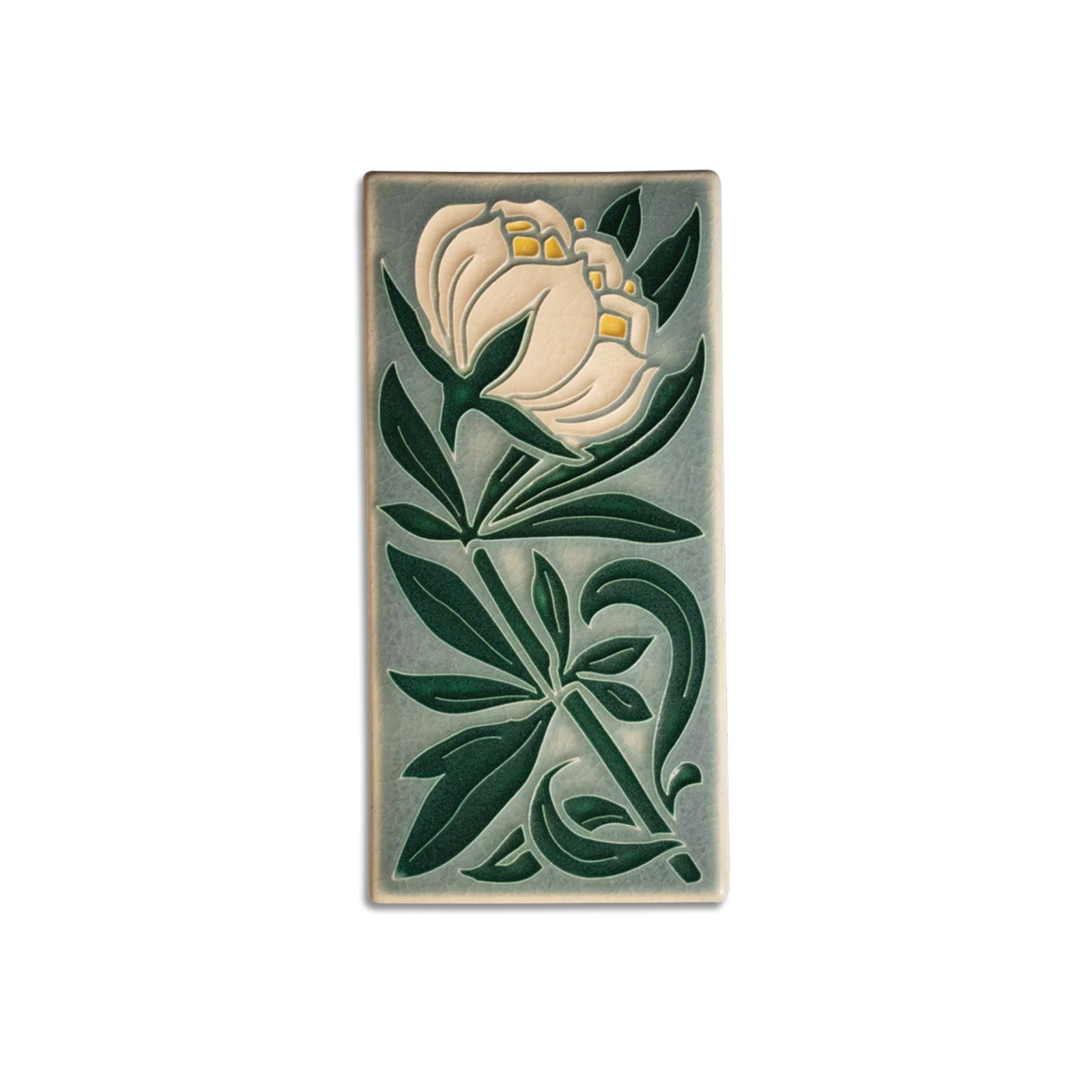 Decorative tile with a white flower and green leaves on a beige background