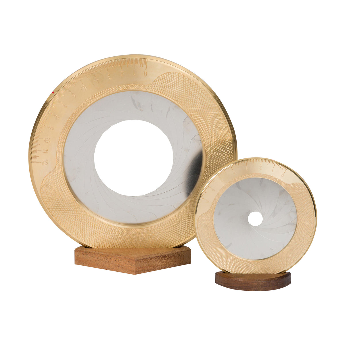 Two gold circular objects with a white center on wooden stands against a white background