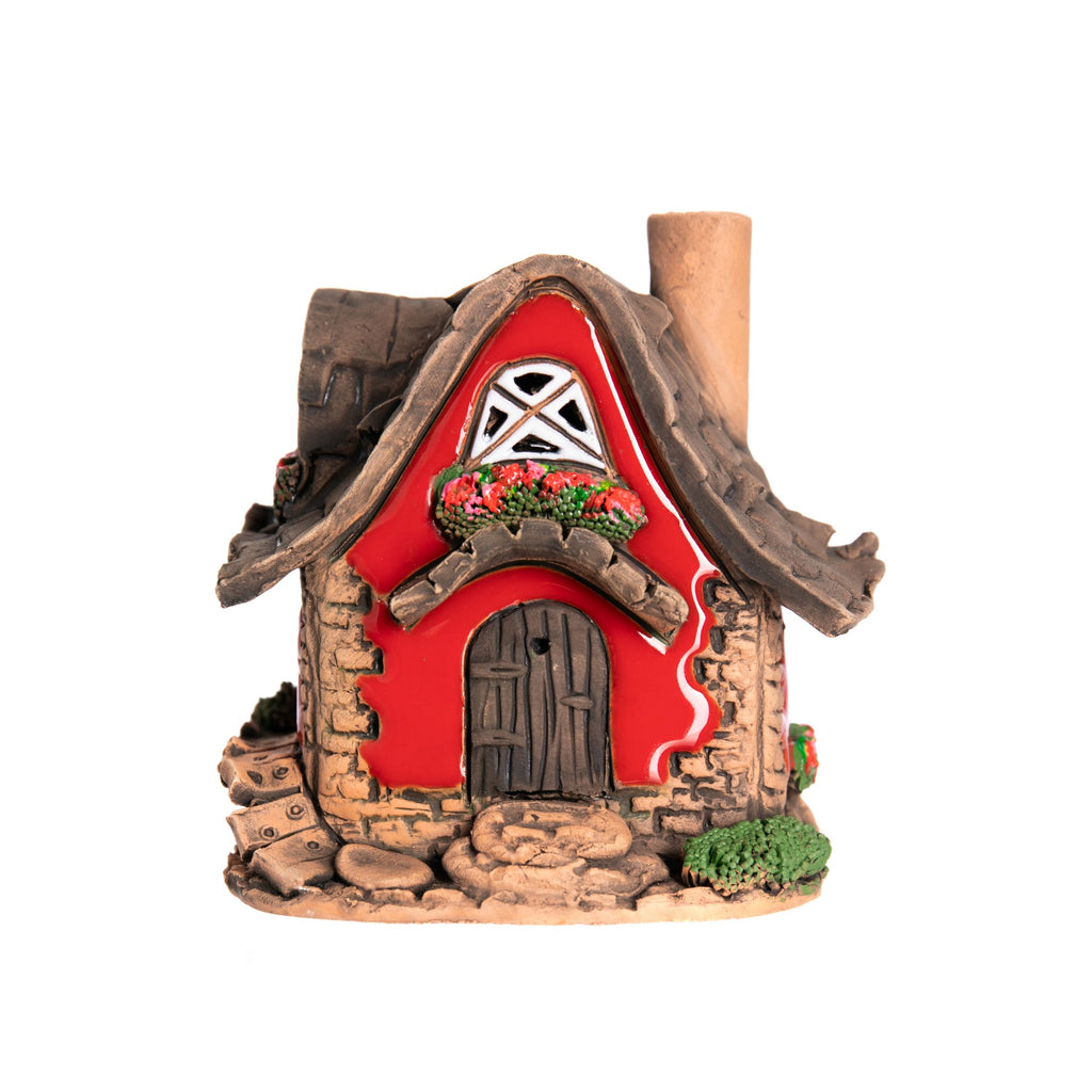 This charming fairy cottage with rosy red exterior is crafted entirely by hand in an artisan ceramics studio in Lithuania. Place a tea-light or cone style incense inside the opening at the back, and the light will glow through the windows, and the smoke will gently swirl out of the artfully crooked chimney. 4.5" x 3.5"