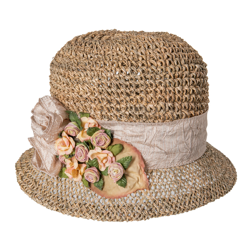 Look stylish in the sun, whilst channeling your inner Daisy Buchanan, with this light café color seagrass cloche with vintage style rosebud trim and gauzy ribbon hat band. Made from natural woven seagrass Silk flower trim Inside circumference: 23". Diameter 7"