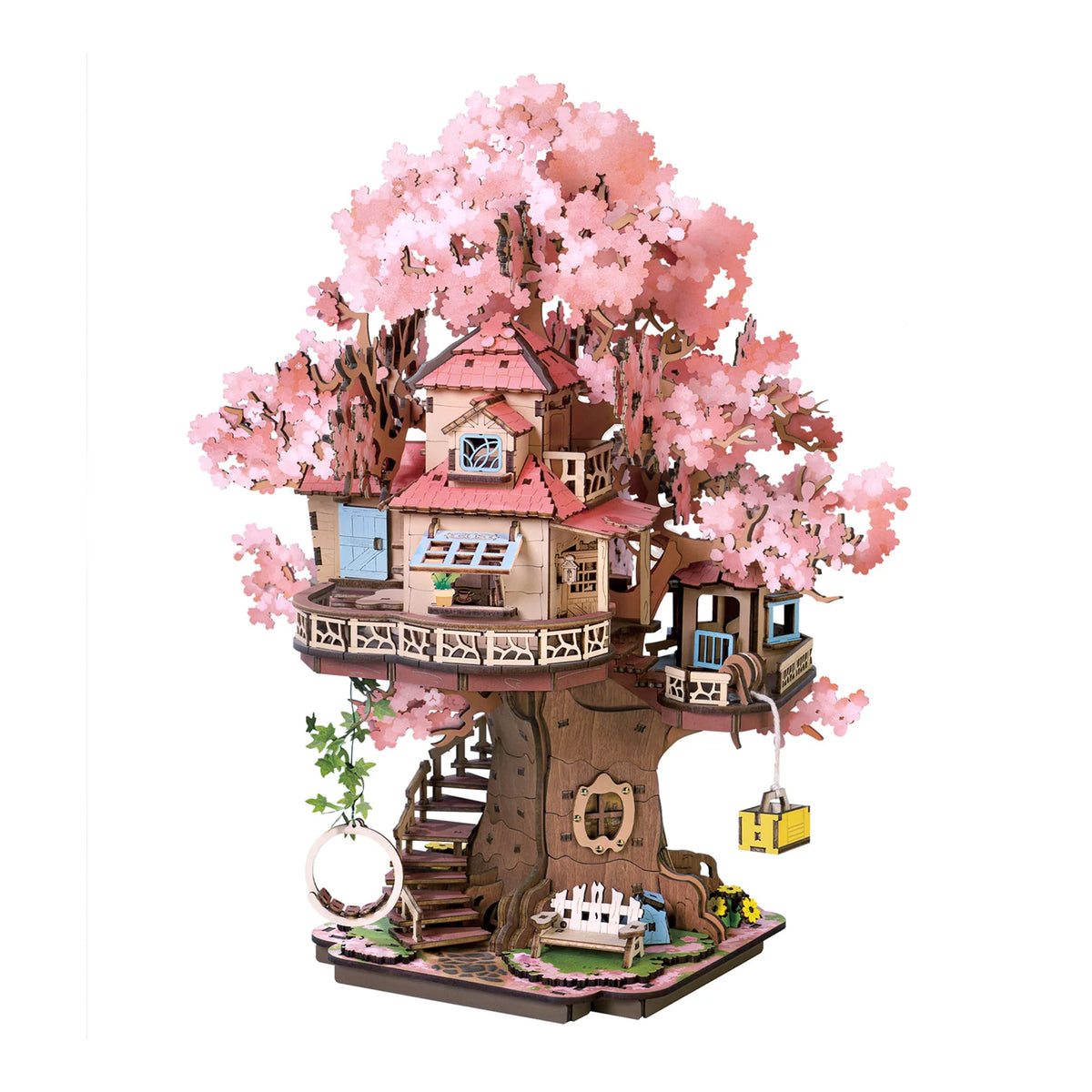 A 3D wooden model puzzle of a treehouse with pink cherry blossom trees, featuring a multi-level house, stairs, a small lift, and a garden bed, isolated on a white background.