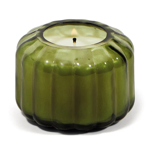This ripple-edge, glass vessel Secret Garden 4.5oz candle is designed to elevate tablescapes. Bring a vintage touch to your next dinner party with this subtle colored glass vessel.  Top Notes: Sea Salt, Melon, Lemon. Middle Notes: Violet, Freesia. Base Notes: Musk, Driftwood Size: 4.5oz. 100% natural soy wax.