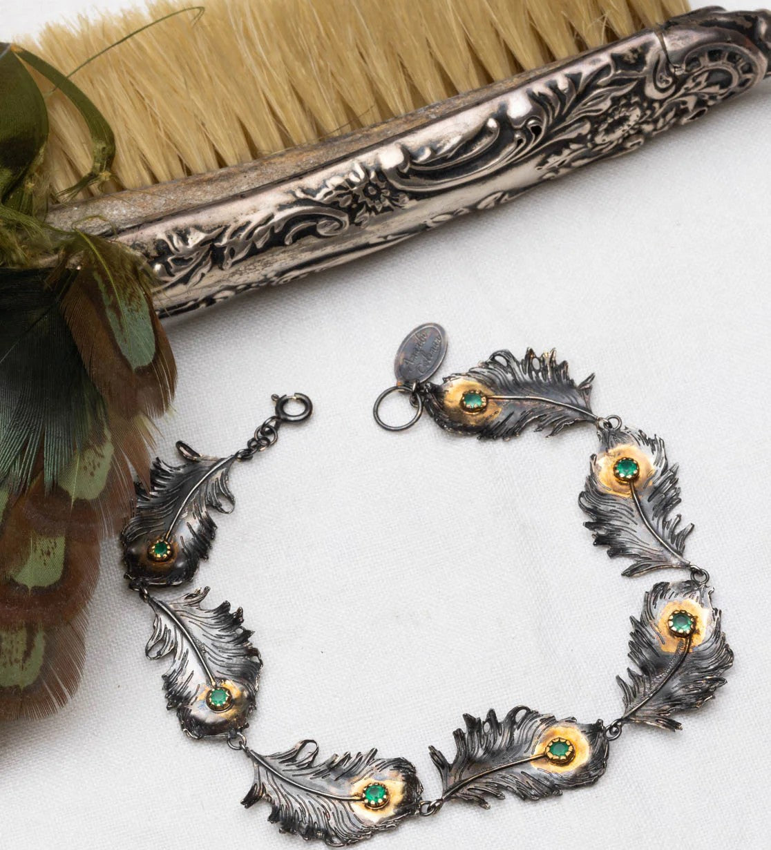Bracelet with feather-shaped charms on a white background