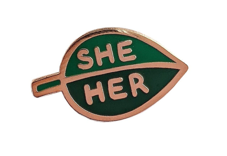 This two-tone enamel leaf she/her pronoun pin allows you to communicate your preferred pronouns in a cute and subtle way. Pin to lapels, backpacks, sneakers and more! Materials: metal and enamel Pin fastening with rubber stopper Dimensions: 1" x 1.5".
