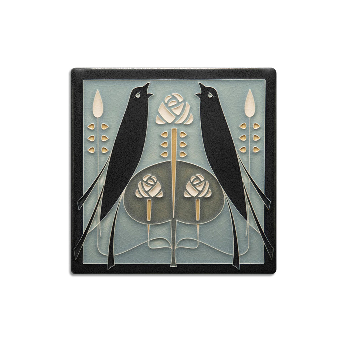 A handcrafted ceramic tile featuring two black birds and a rose design in beige and darker shades on a light blue background.