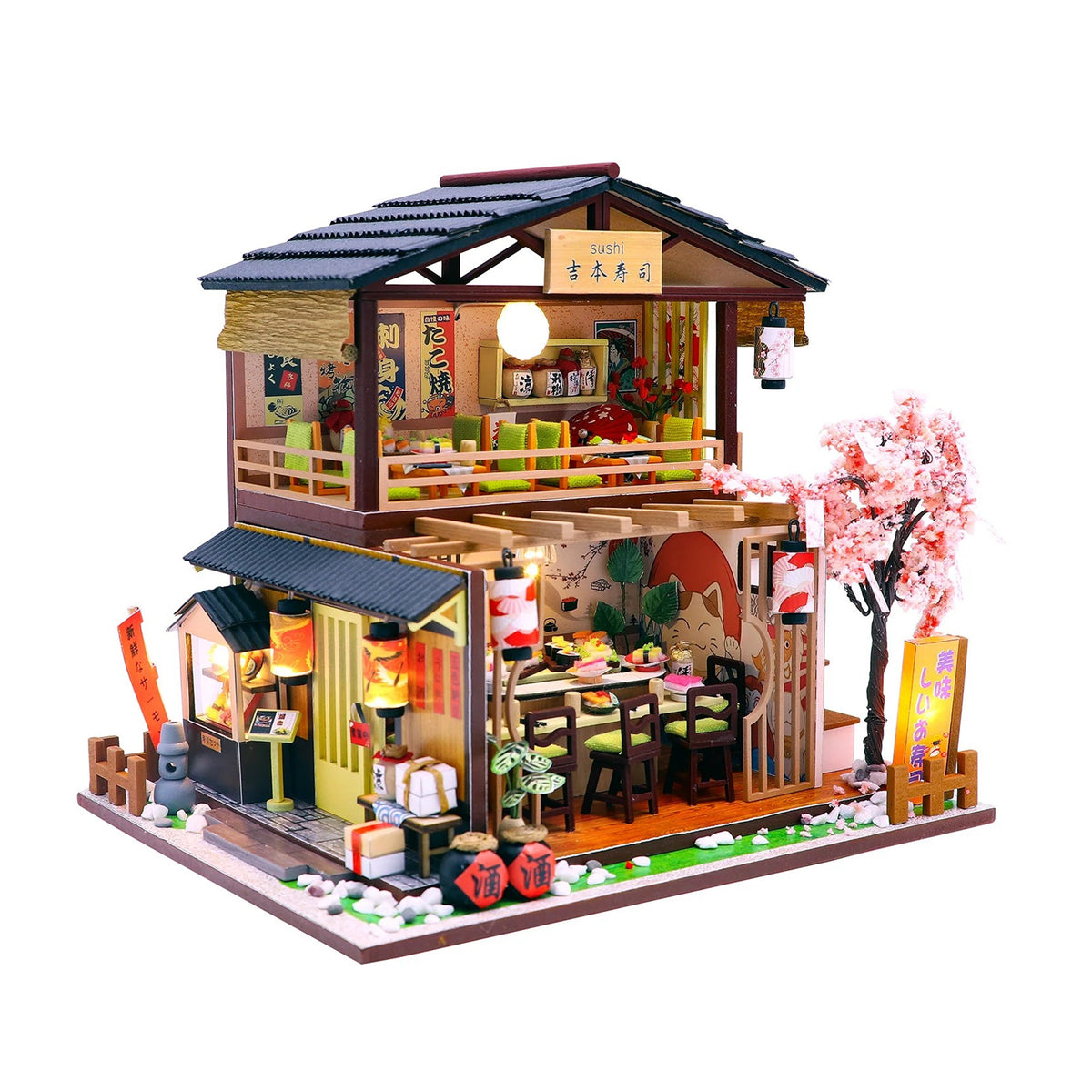 A detailed miniature Japanese-style house model with a two-story restaurant design, featuring pink cherry blossom trees, red lanterns, and warm yellow interior lighting, isolated on a white background.