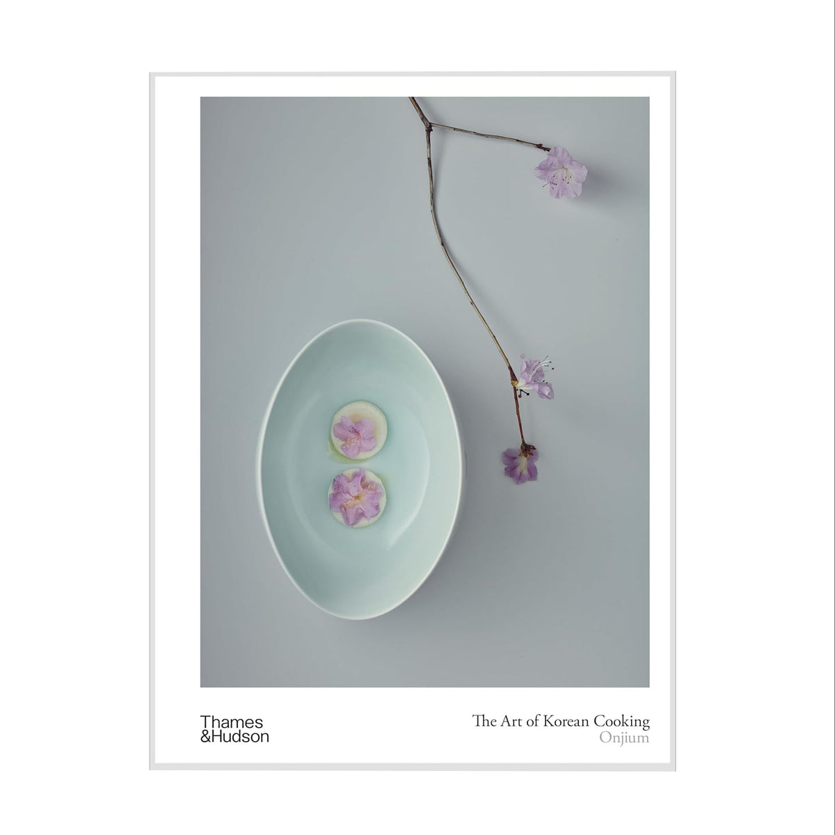Book cover of 'The Art of Korean Cooking' with a photo of a light blue ceramic dish with pink flowers on a gray background.