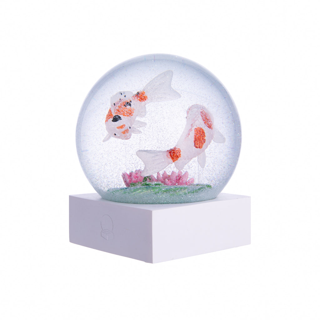 Koi have often been called “swimming jewels.” They are symbols of friendship, love and peace.  Celebrate this graceful and majestic creature with this delightful snow globe. Please note: Please keep your globe out of direct sunlight. As the globe is made of glass, it is not a toy and is not recommended for younger children. Glass snow globe with wood base Dimensions: 4.5" x 4.5" x 3.5"