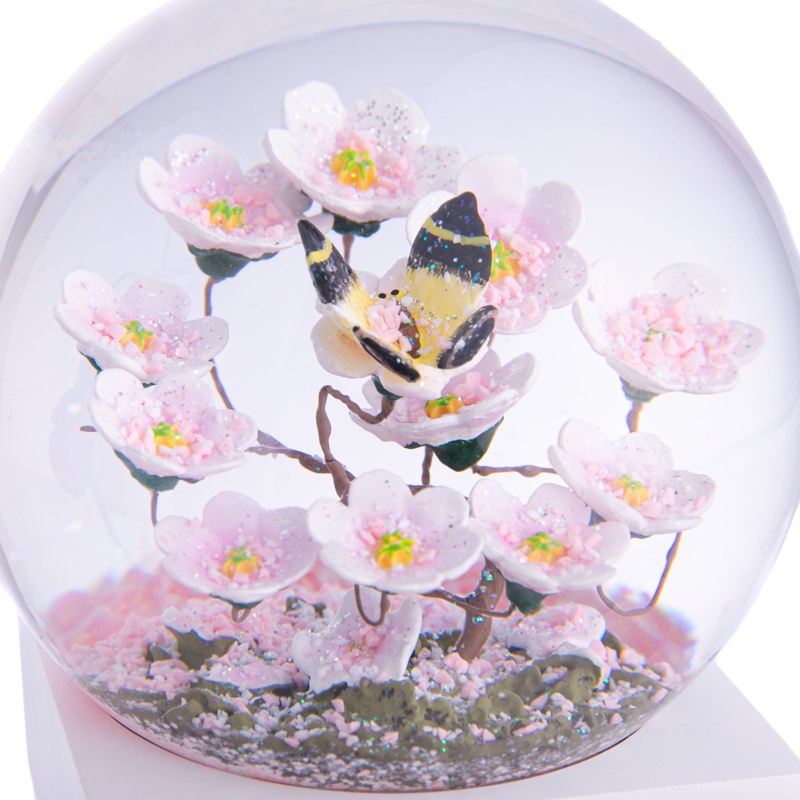 Add the beauty of a sunny spring day to your home year-round with this delightful snow globe. Please note: Please keep your globe out of direct sunlight. The globe is made of glass. It is not a toy and not recommended for younger children. Glass snow globe with wood base Dimensions: 4.5" x 4.5" x 3.5"