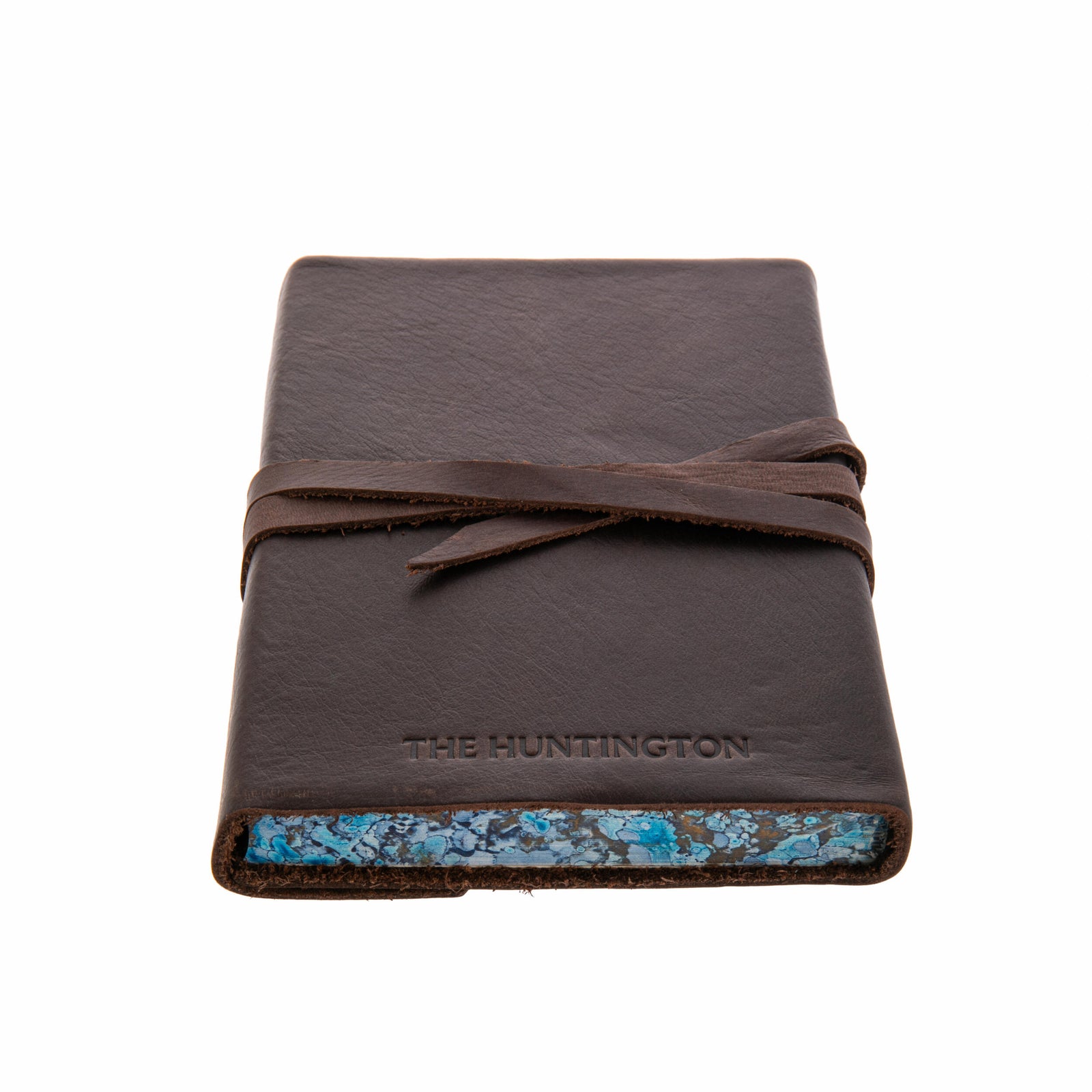 Brown leather-bound book with a strap closure on a white background