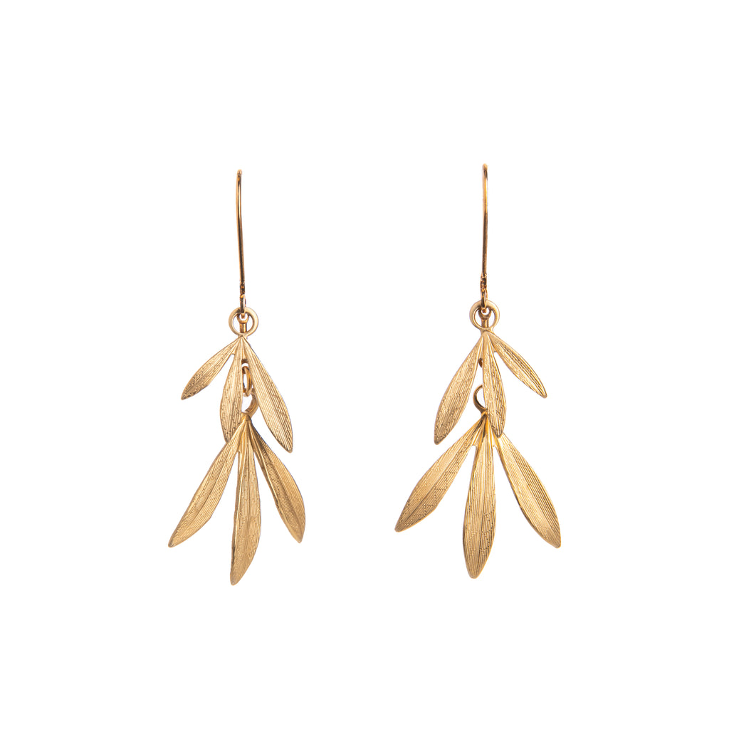 Evoke a tranquil bamboo forest swaying in the wind with these gold-plated brass bamboo leaf earrings.   They add a subtle flash of natural glamour to any outfit, and can be worn day or night. With lever-back clasps for easy attachment.  Material: Gold-plated brass  Dimensions: 1.75" long Nickle and lead-free