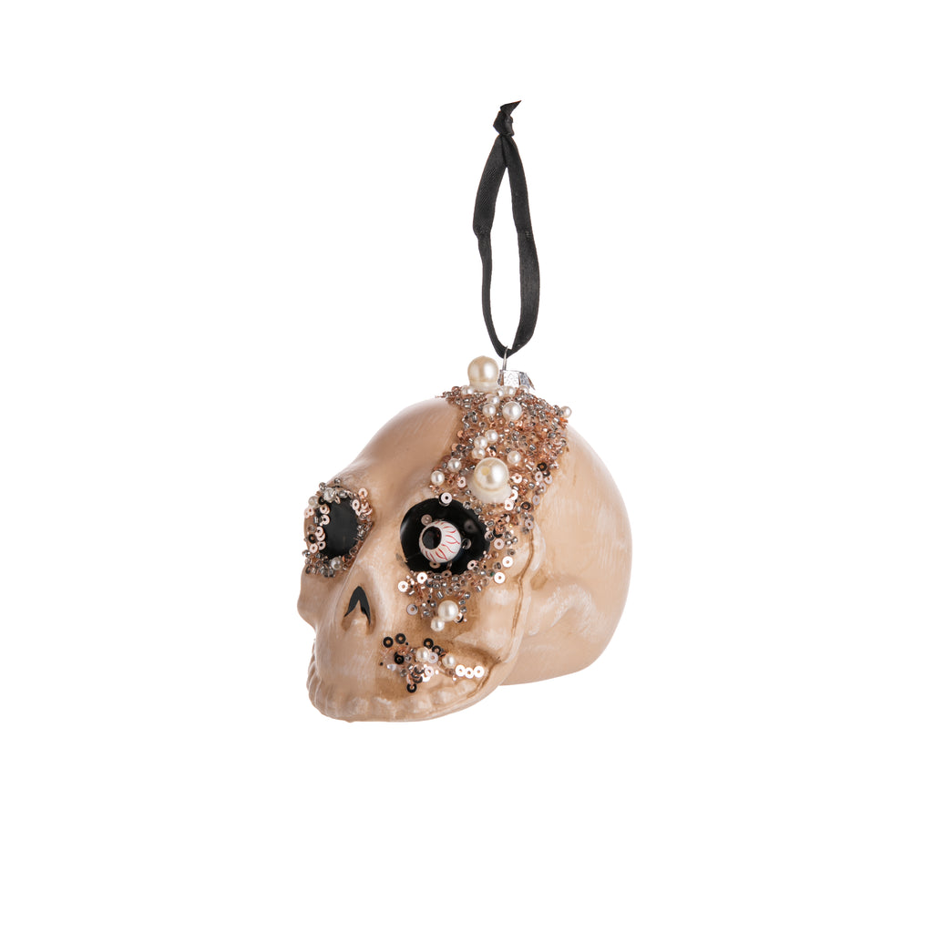 Zombies in all their undead glory deserve to have a little glitz and glam too! Zombi-fy your Halloween decor or your holiday tree with this glass ornament of a zombie head. With sequin and faux pearl detail, this zombie is sure to serve undead glamour. A mix of Halloween and holiday! Glass ornament Dimensions: 4.75"