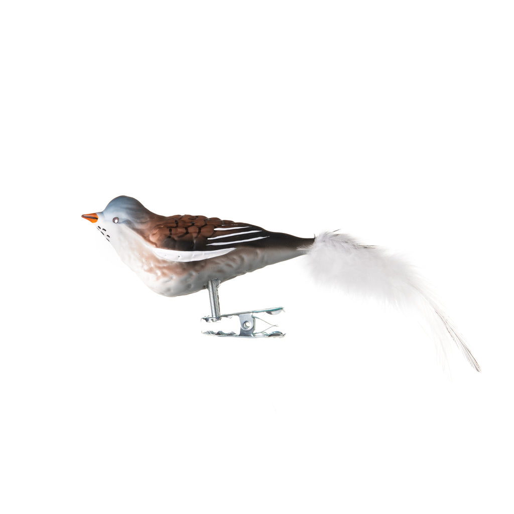 This winterbound snow finch is made from hand-blown glass in a family-owned studio. Its tail is made with real feathers and has a hand-painted finish.