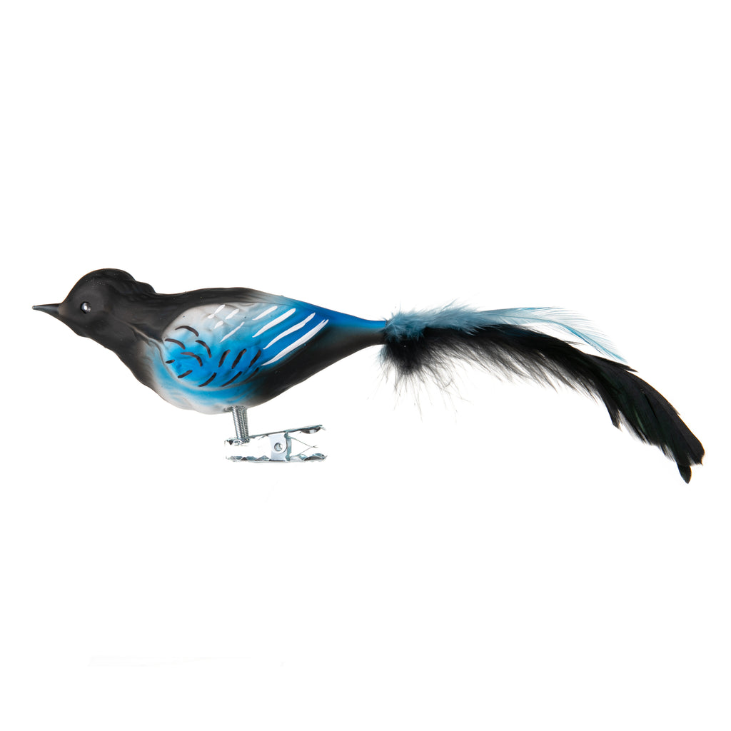 Watch out - the mischievous Magpie just loves to steal anything that sparkles! Luckily, this particular feathered friend will in fact add sparkle to your holiday decor. Made from hand-blown glass in a traditional family-owned studio in Limbach, Germany. Attaches with a strong clip. Dimensions: 6" long x 2" height.