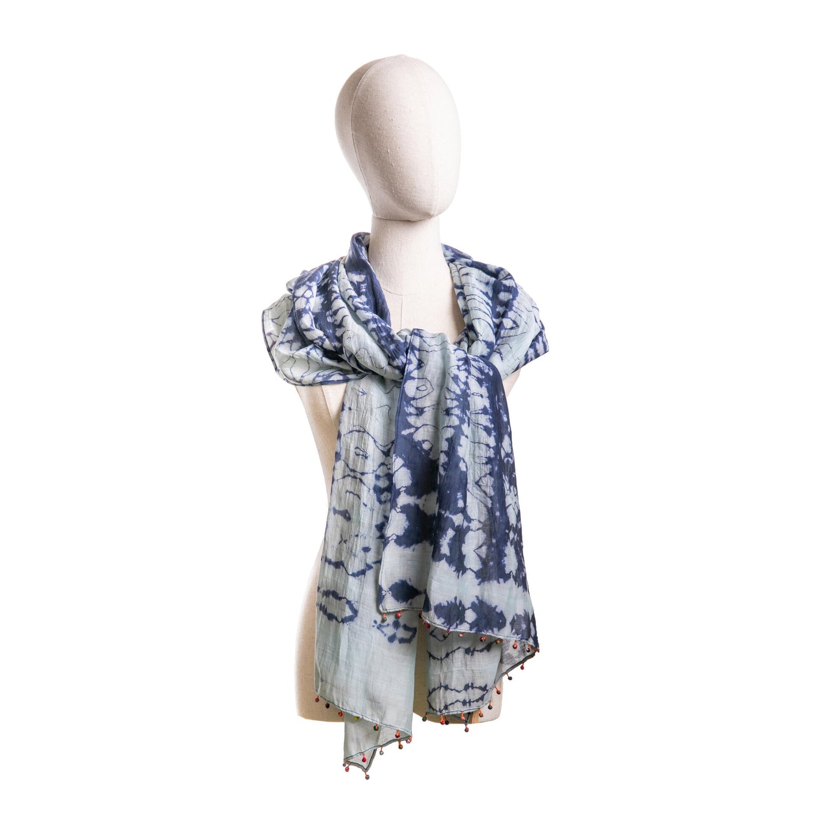 Mannequin wearing a blue and white patterned scarf on a white background