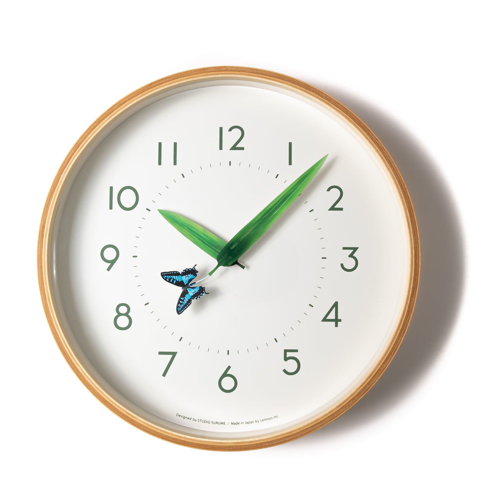 Once an hour, when the minute hand and the hour hand line up perfectly, the butterfly will land on the leaves to rest. The hands on the clock are shaped and colored like leaves. At the end of one of the leaves sits a blue butterfly. The clock is encircled by a handmade natural plywood frame. Diameter: 10". Depth 13/4" 