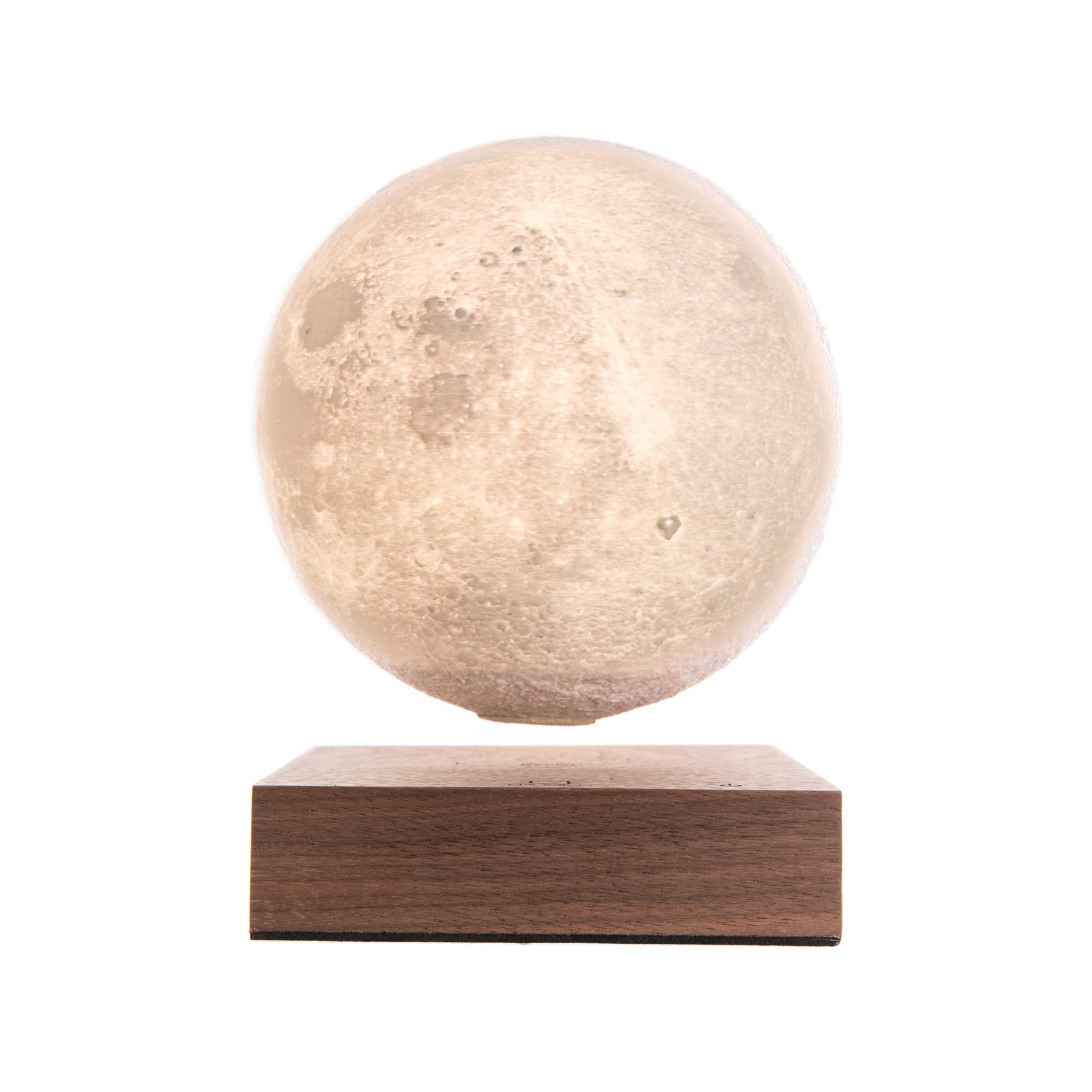 A rotating moon lamp with a textured surface, floating above a walnut wood base, illuminated in a warm white light.