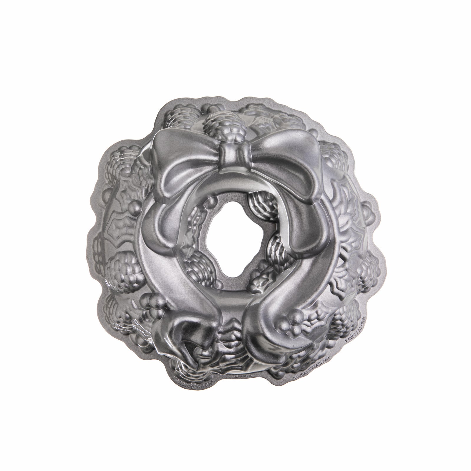 Metal Bundt cake pan with decorative lid on a white background