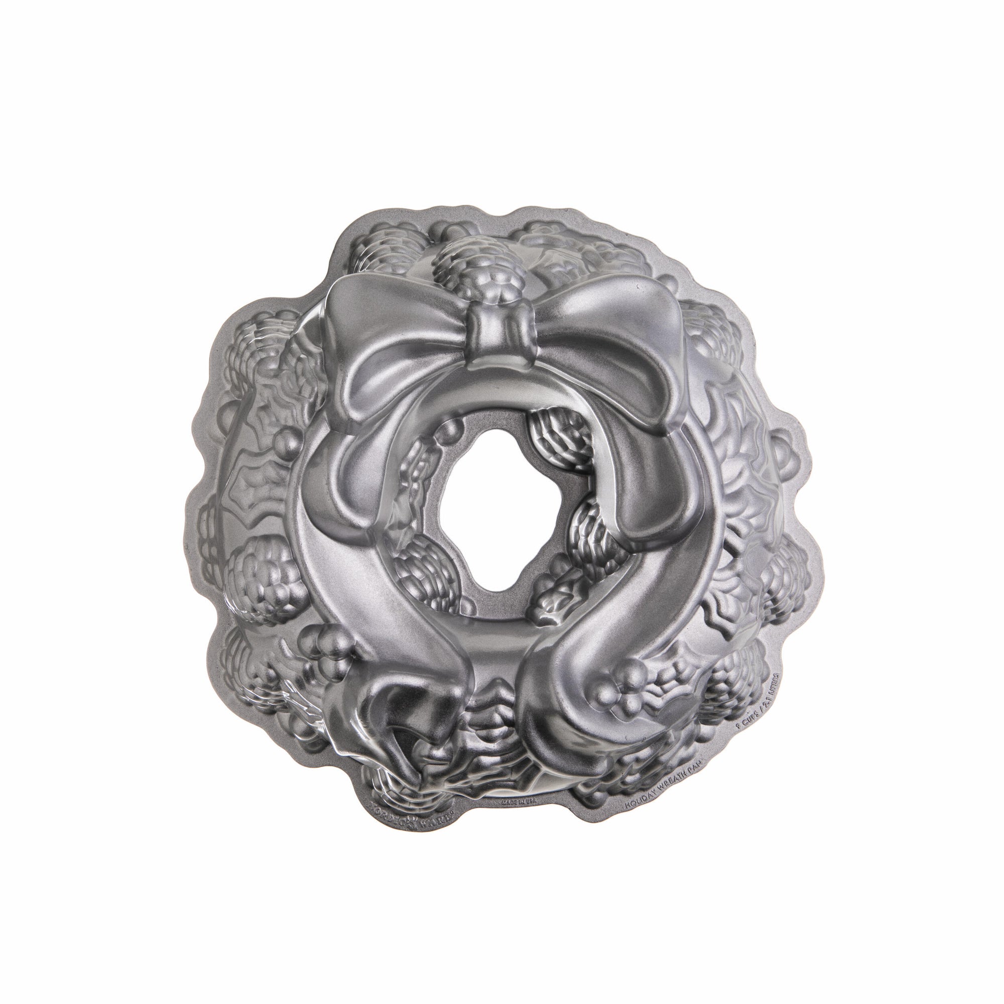 Metal Bundt cake pan with decorative lid on a white background