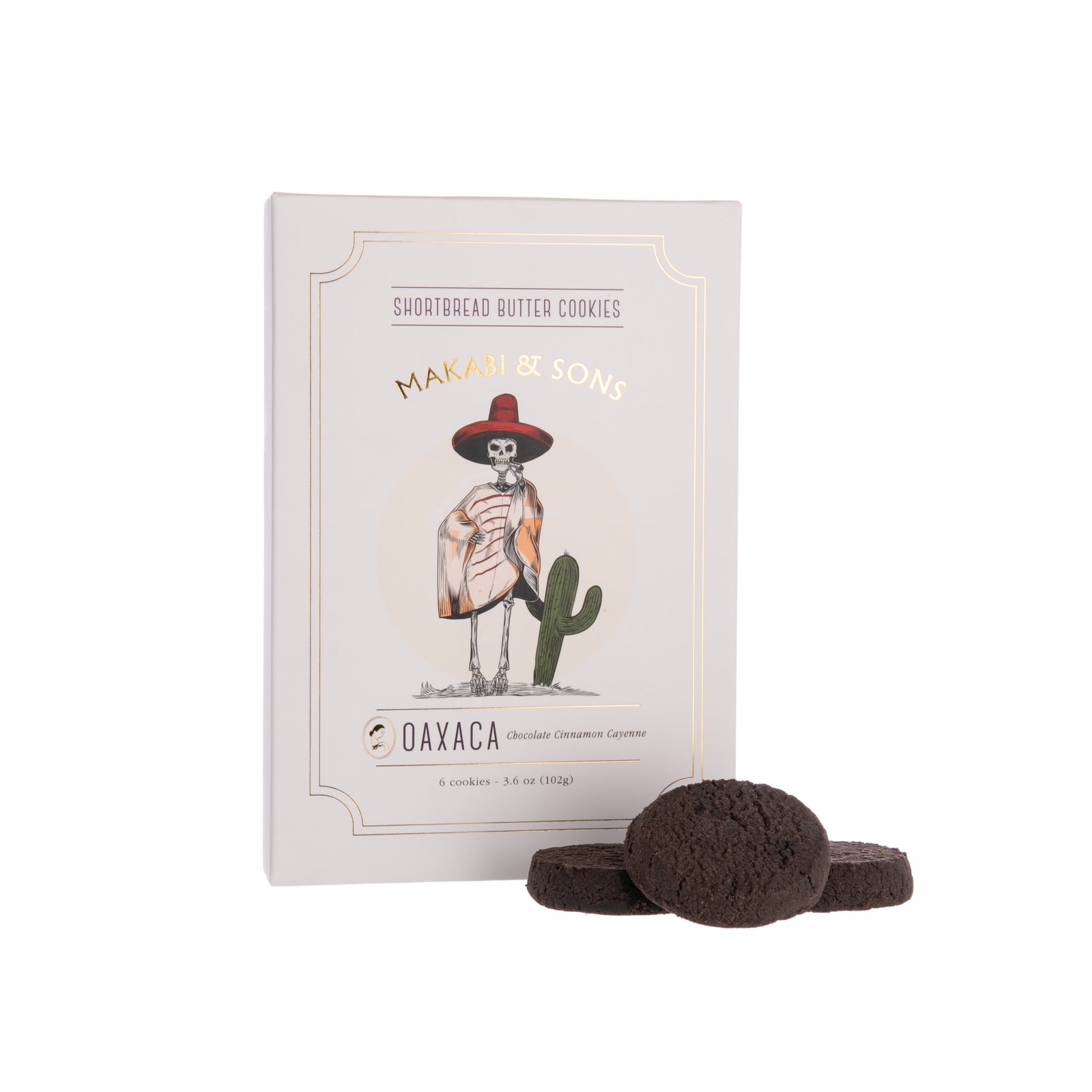 Package of Makabi & Sons cinnamon and cayenne chocolate cookies with some cookies displayed in front of the package.