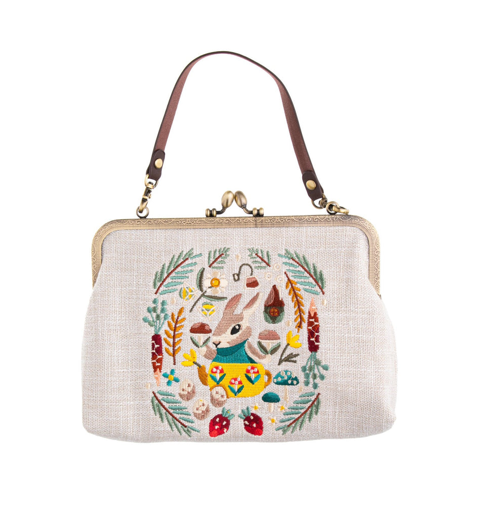 Hop stylishly into spring with this delightful, embroidered purse. This fabulous accessory combines a classic design with an adorable bunny motif. The colorful embroidery on a linen fabric base is topped with a vintage-style metal frame. Vintage-style embossed metal frame