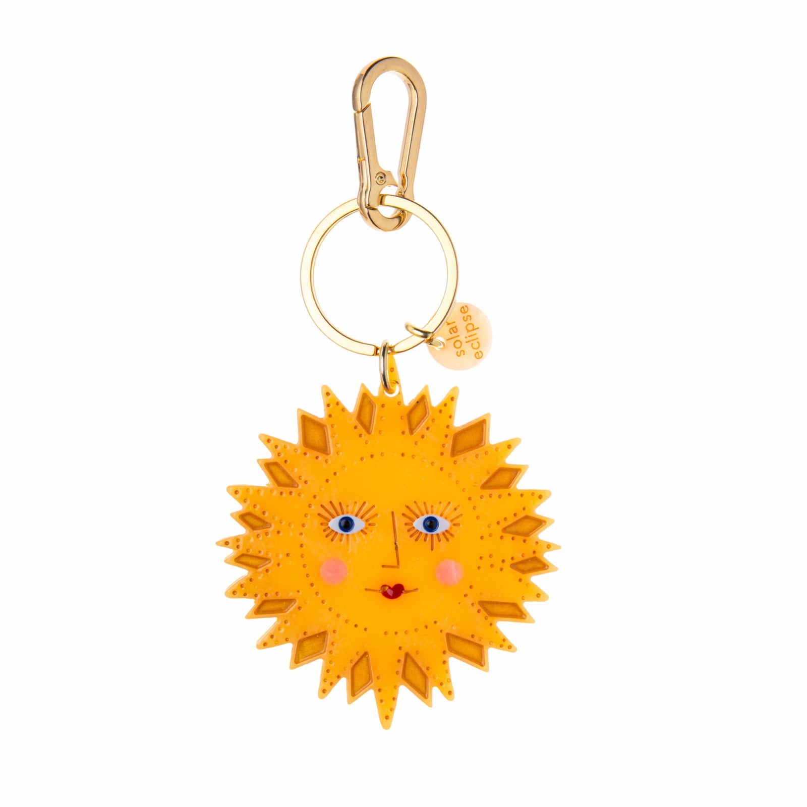 Yellow sun-shaped keychain with a face on a white background