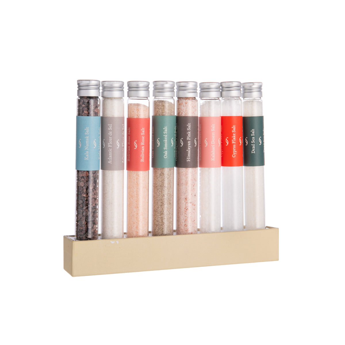 Set of nine small glass jars with different colored labels on a beige stand against a white background.