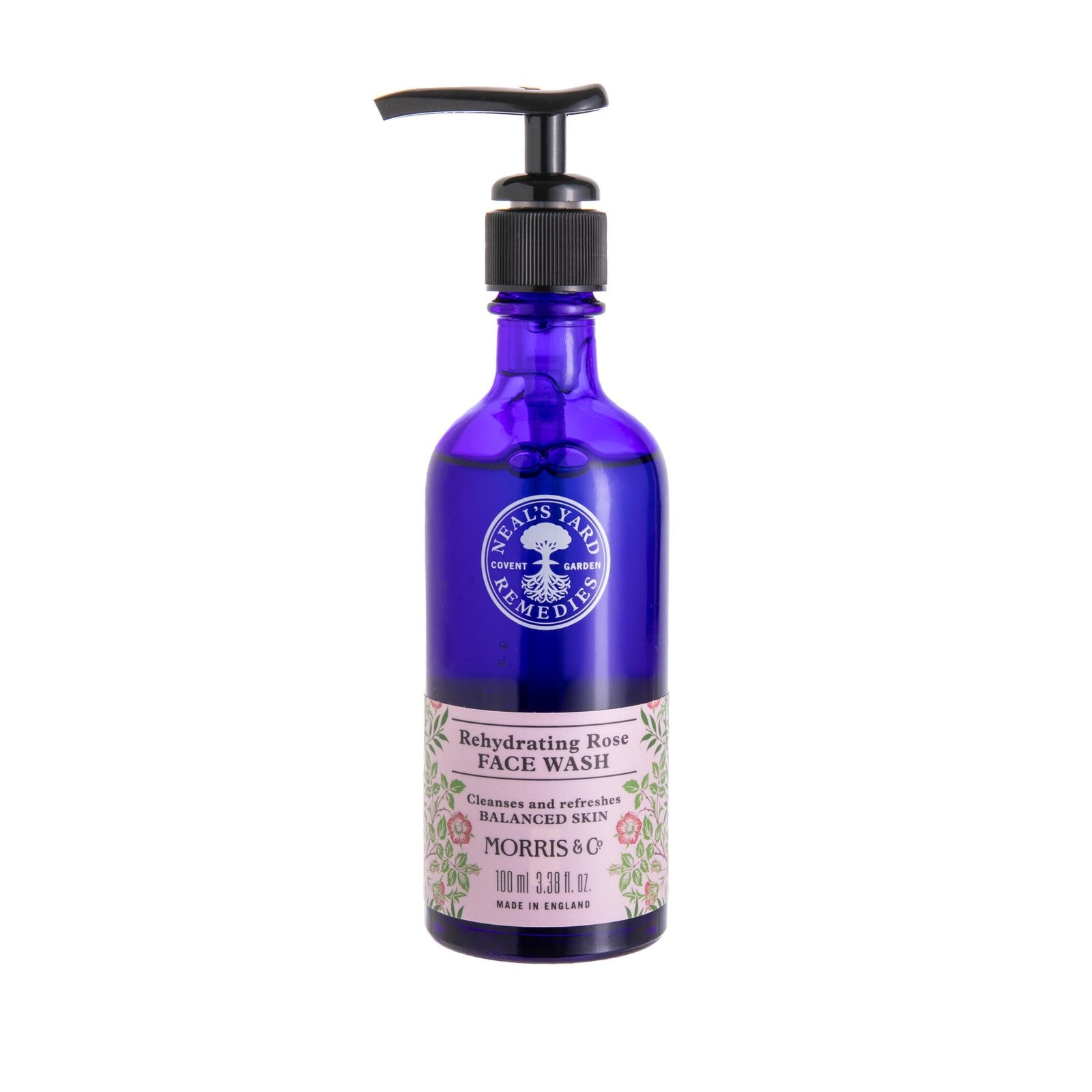 Blue bottle with pump bottle of Neal's Yard Rehydrating Rose Face Wash in a blue bottle with a William Morris floral print on a white background