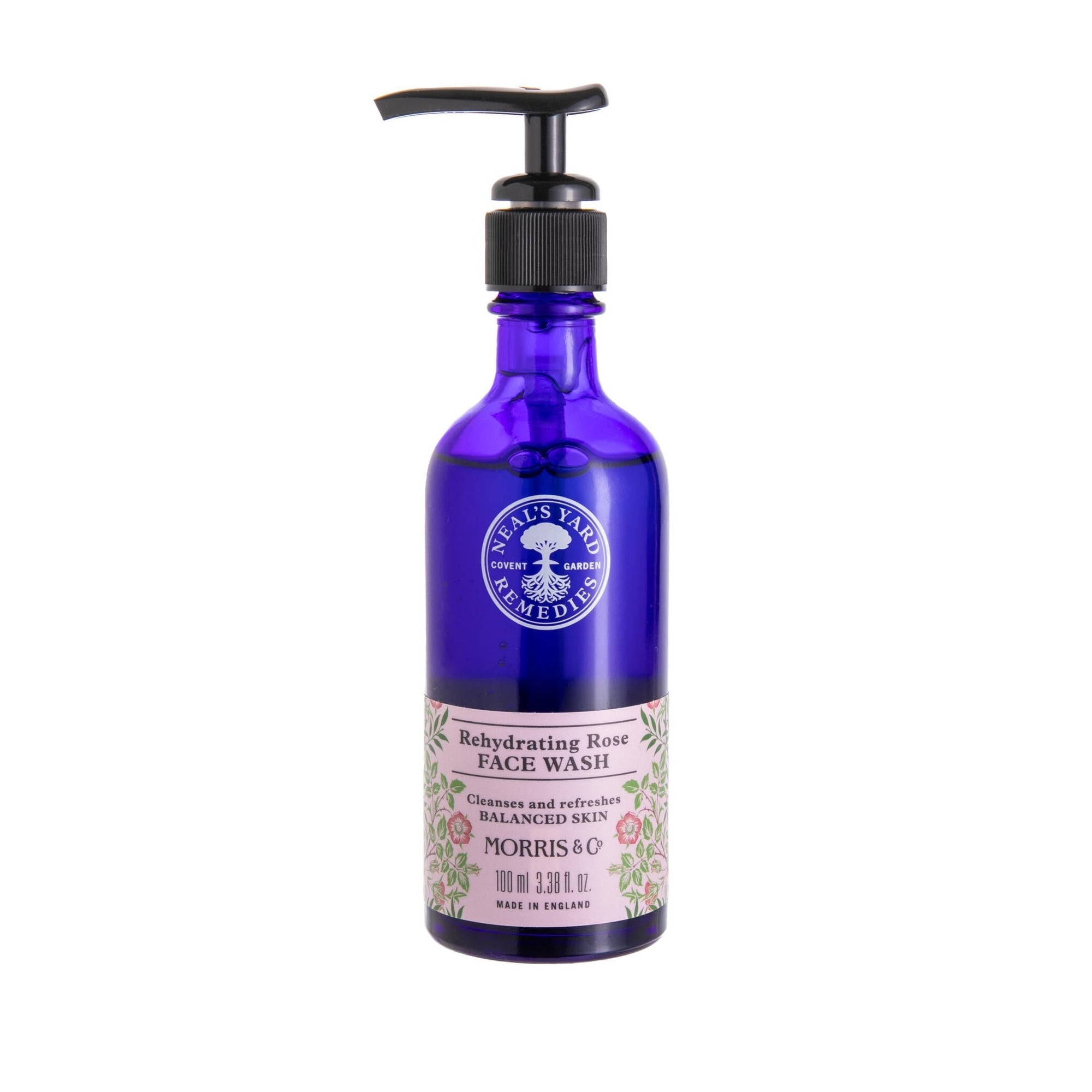 Blue bottle with pump bottle of Neal's Yard Rehydrating Rose Face Wash in a blue bottle with a William Morris floral print on a white background